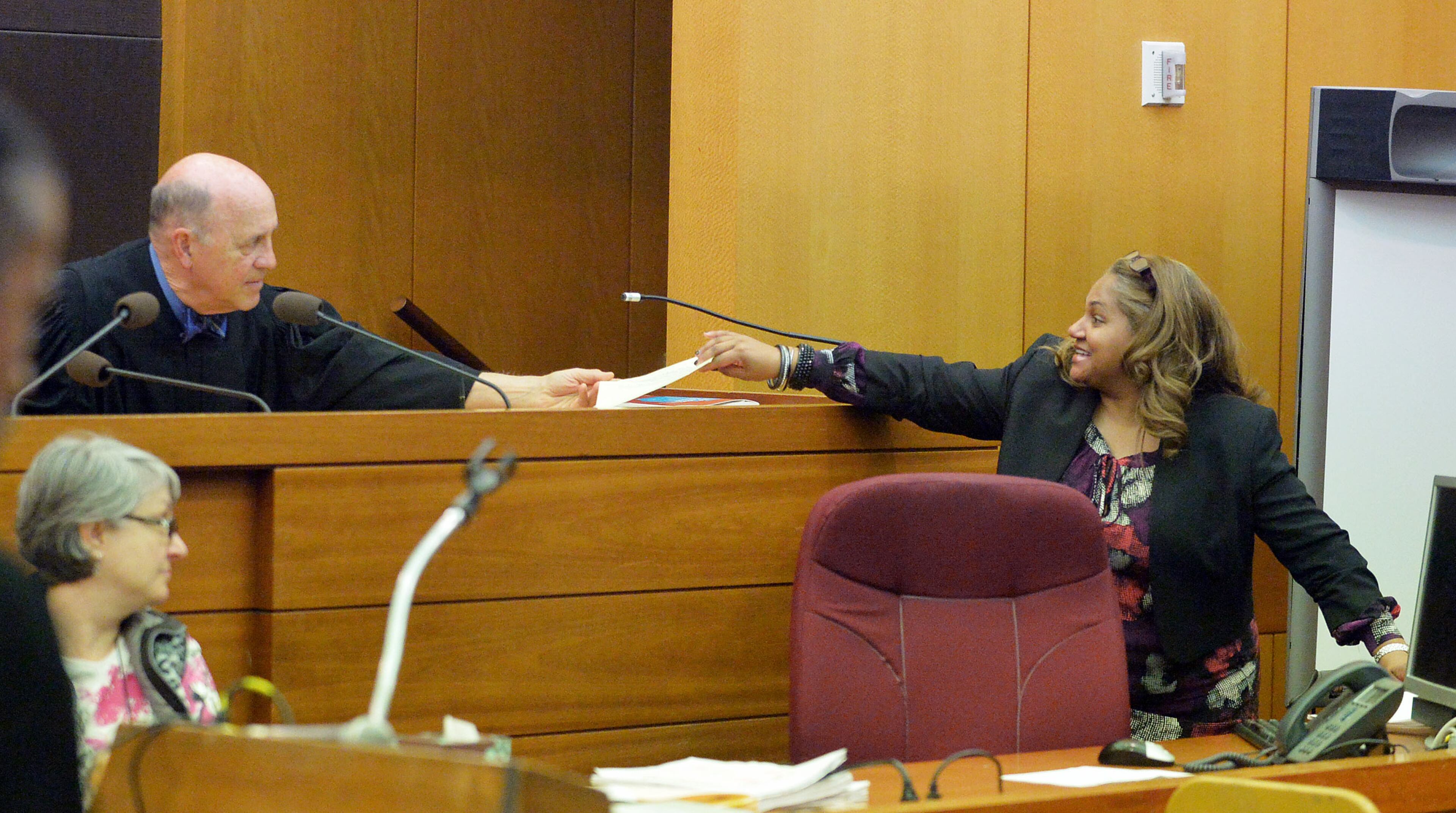 Fulton County Superior Court Judge Jerry Baxter hands a jury question to defense attorney Teresa Mann on Wednesday. A jury of six men and six women deliberated for a fourth day in the Atlanta Public Schools test-cheating trial, considering roughly five months of testimony against 12 former educators accused of engaging in a racketeering conspiracy to inflate test scores. (Atlanta Journal-Constitution, Kent D. Johnson, Pool)