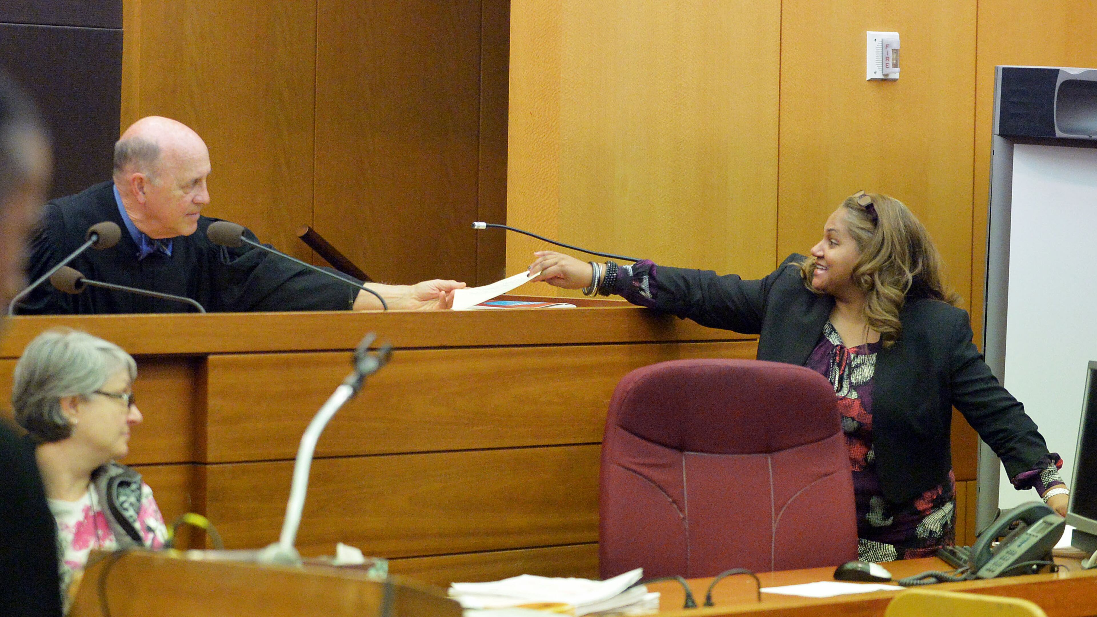Fulton County Superior Court Judge Jerry Baxter hands a jury question to defense attorney Teresa Mann on Wednesday. A jury of six men and six women deliberated for a fourth day in the Atlanta Public Schools test-cheating trial, considering roughly five months of testimony against 12 former educators accused of engaging in a racketeering conspiracy to inflate test scores. (Atlanta Journal-Constitution, Kent D. Johnson, Pool)