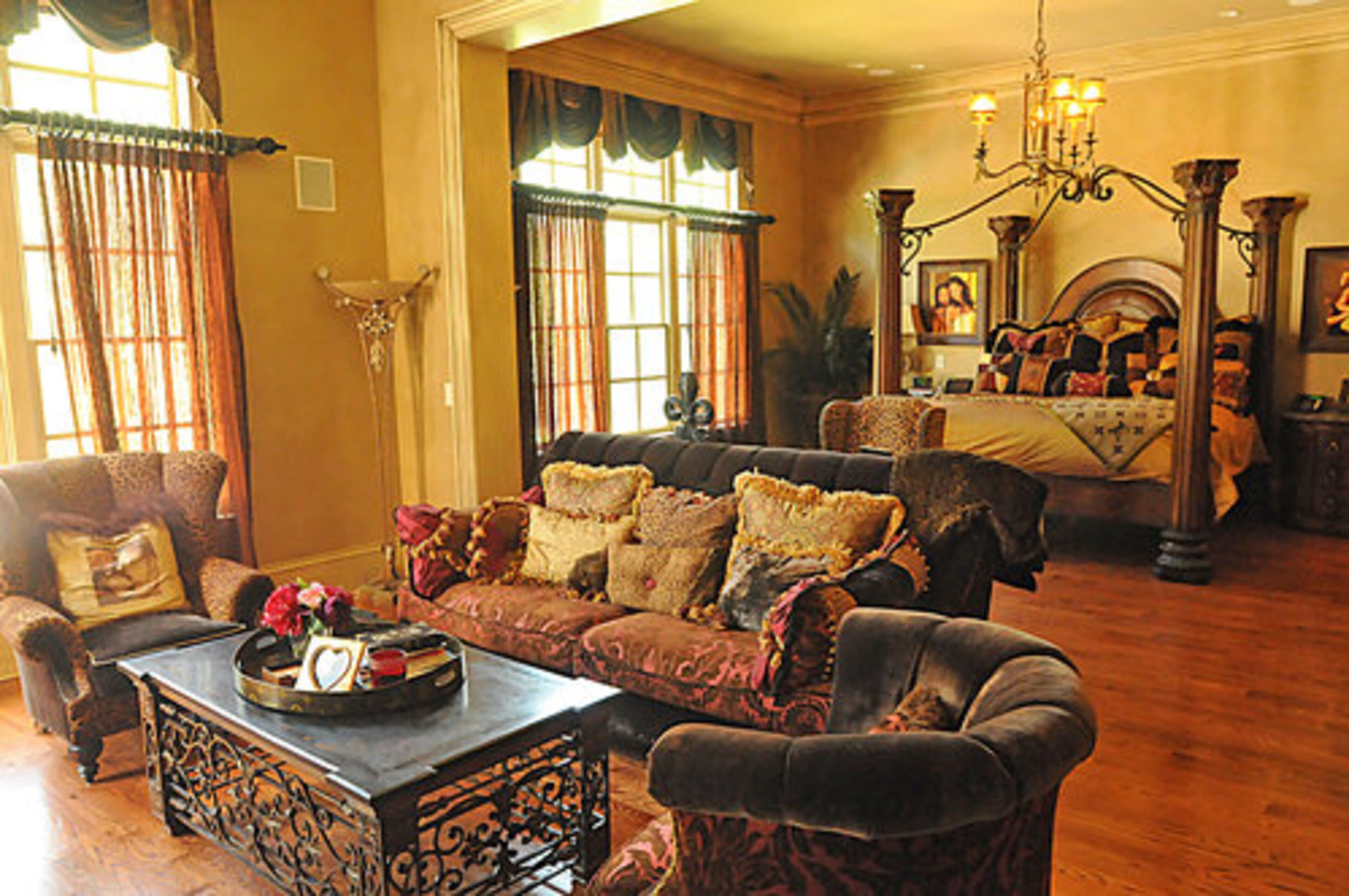 The spacious master bedroom features a morning kitchen and separate sitting room. Large windows allow in a generous amount of natural light, and the beautiful light fixture over the bed offers a gentle glow.