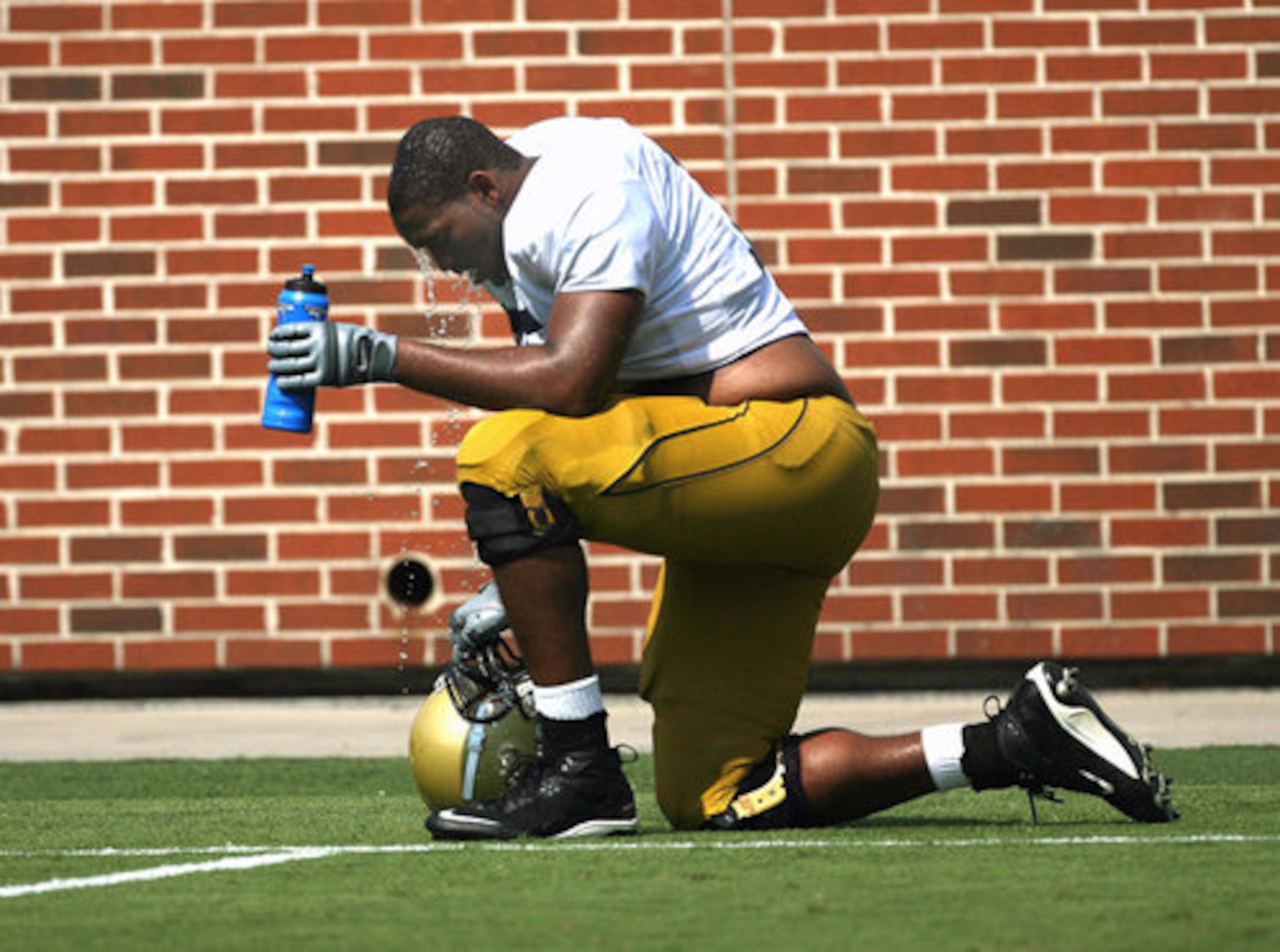 With the temperture reaching above 97 degrees on the football field, Tech offensive lineman Nick Claytor cools off with some water.