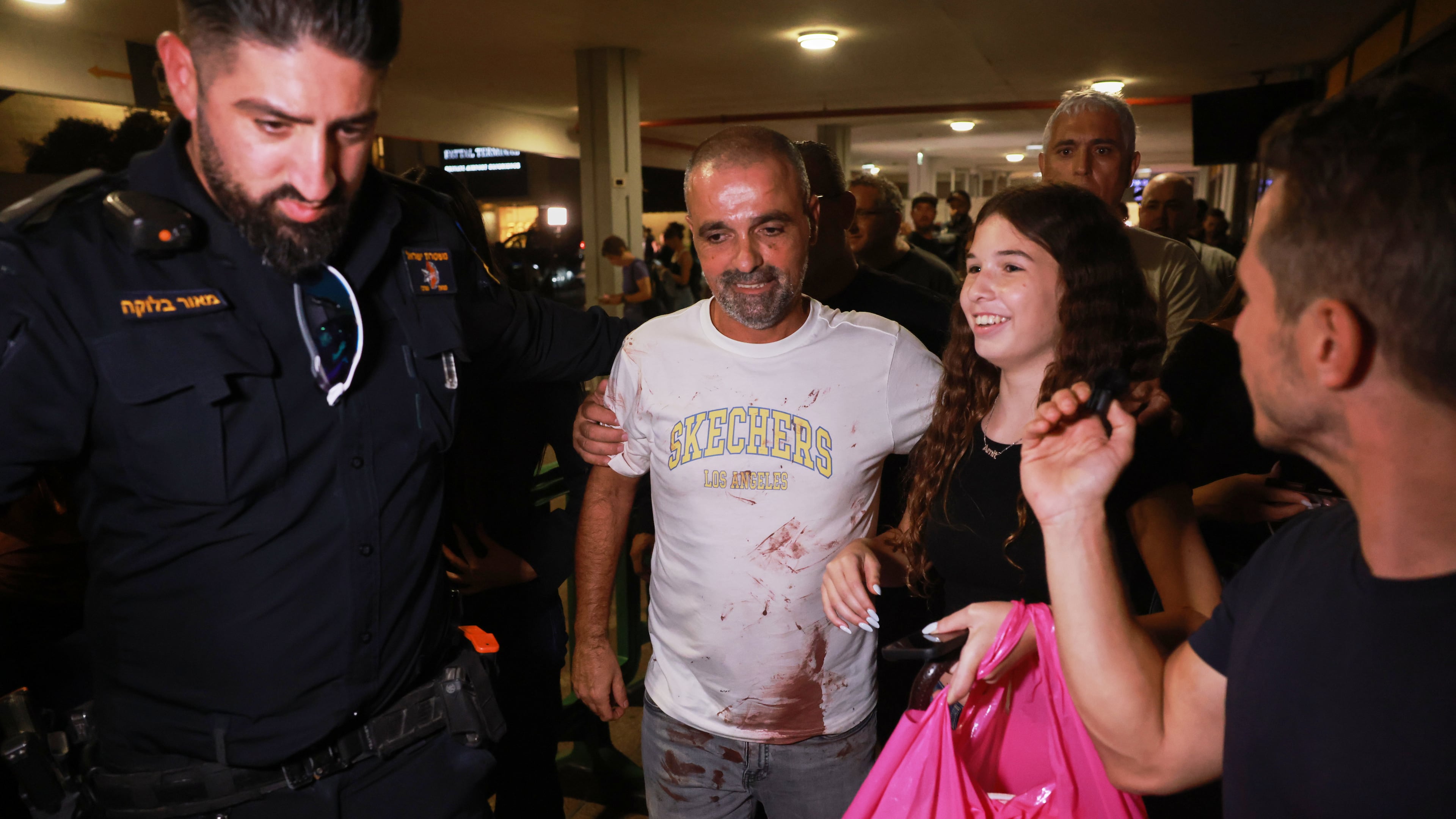 Israeli passenger Yaniv Hayoun, with blood stains on his shirt, who was aboard a Flydubai aircraft that made an emergency landing in Saudi Arabia, is welcomed at the arrivals gate at Ben Gurion International Airport near Tel Aviv, Israel, Wednesday, Sept. 30, 2026. (AP Photo/Tomer Appelbaum)