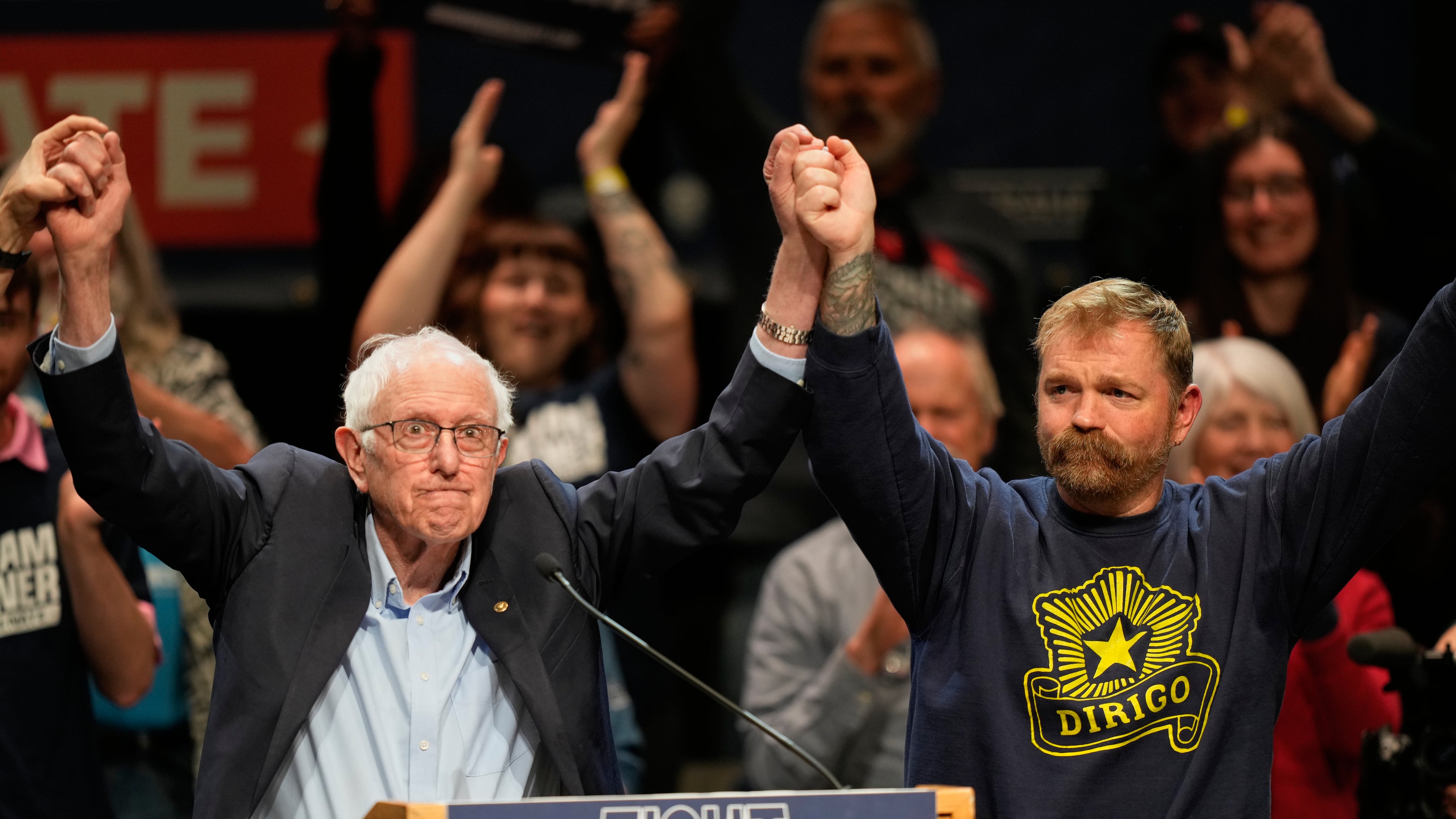 Graham Platner, Democratic candidate for U.S. Senate, and Sen. Bernie Sanders, left, join hands at an event in Orono, Maine, Sunday, May 24, 2026. (AP Photo/Robert F. Bukaty)