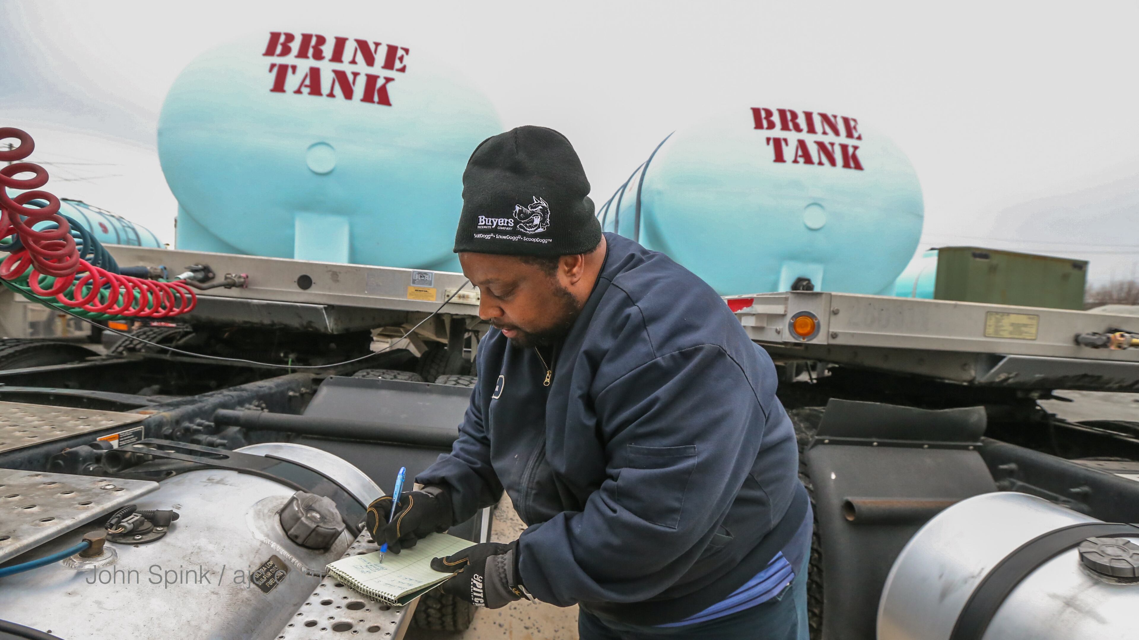 Randy Walker walks by 19 brine tanks at the Georgia Department of Transportation facility on Kennedy Drive in Forest Park.