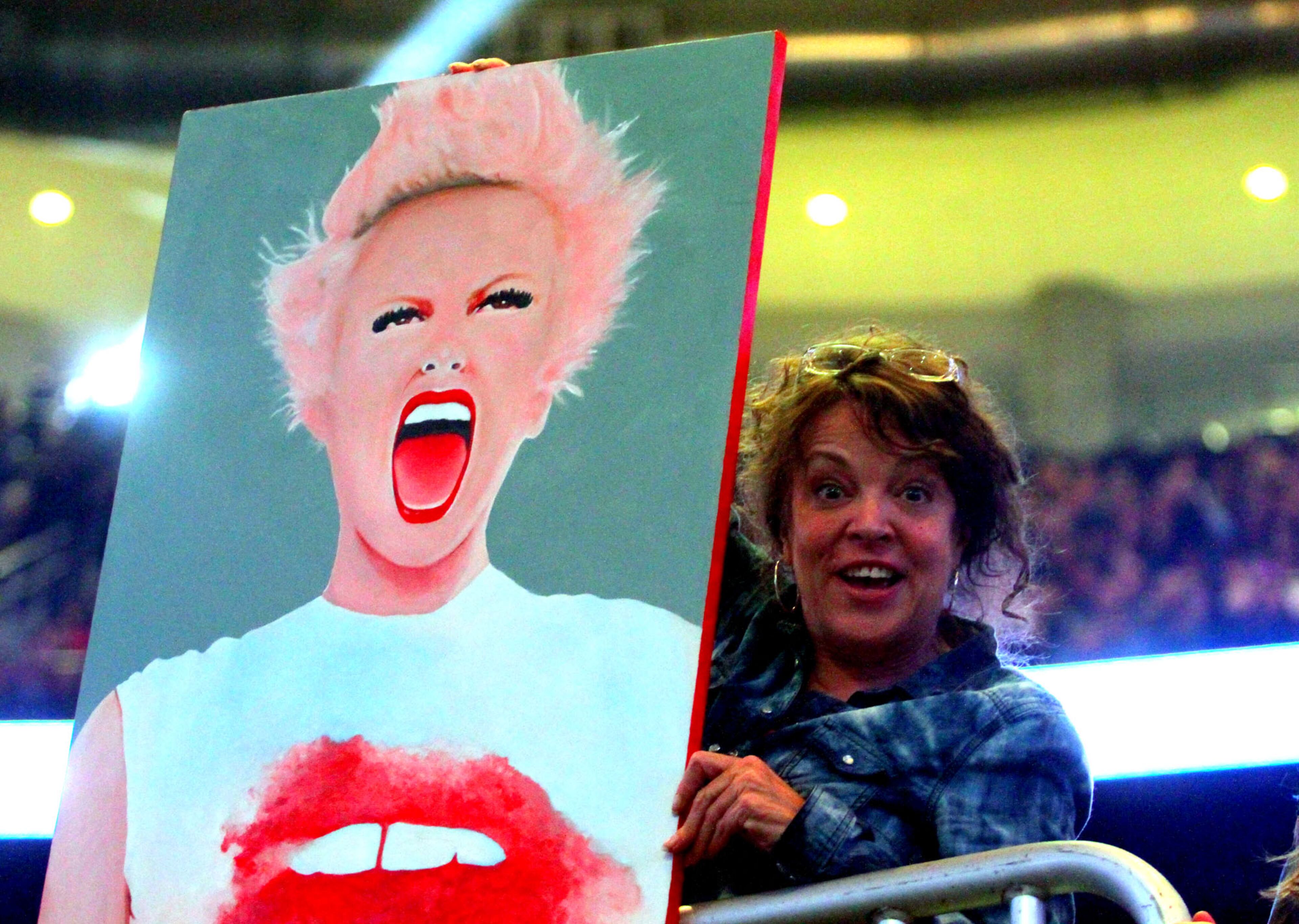 A fan displays a poster of Pink before the show.