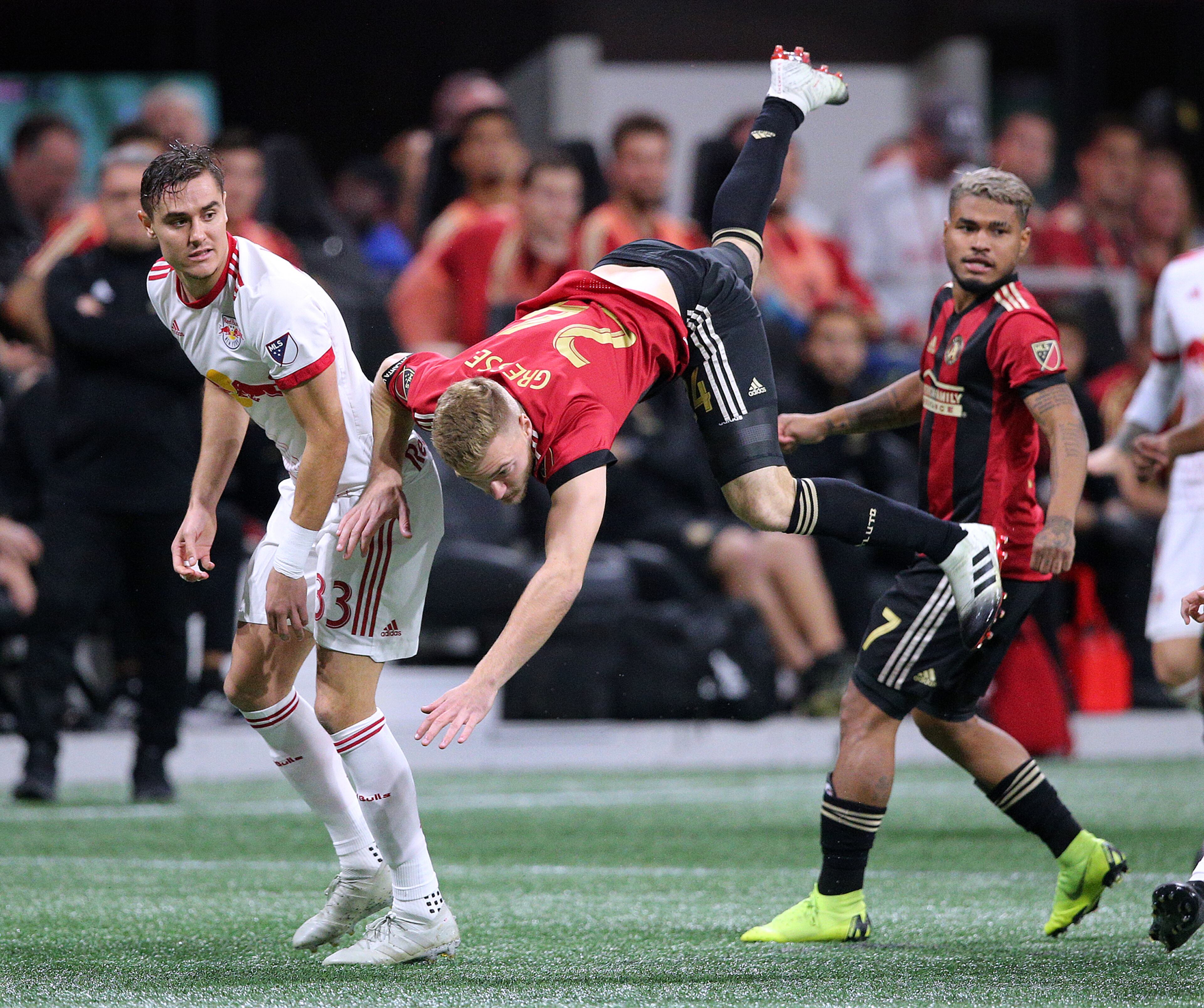Atlanta United midfielder Julian Gressel is sent flying on a collision while New York Red Bulls defender Aaron Long looks on during the first half in their Eastern Conference finals MLS soccer game on Sunday, Nov. 25, 2018, in Atlanta. Curtis Compton/ccompton@ajc.com