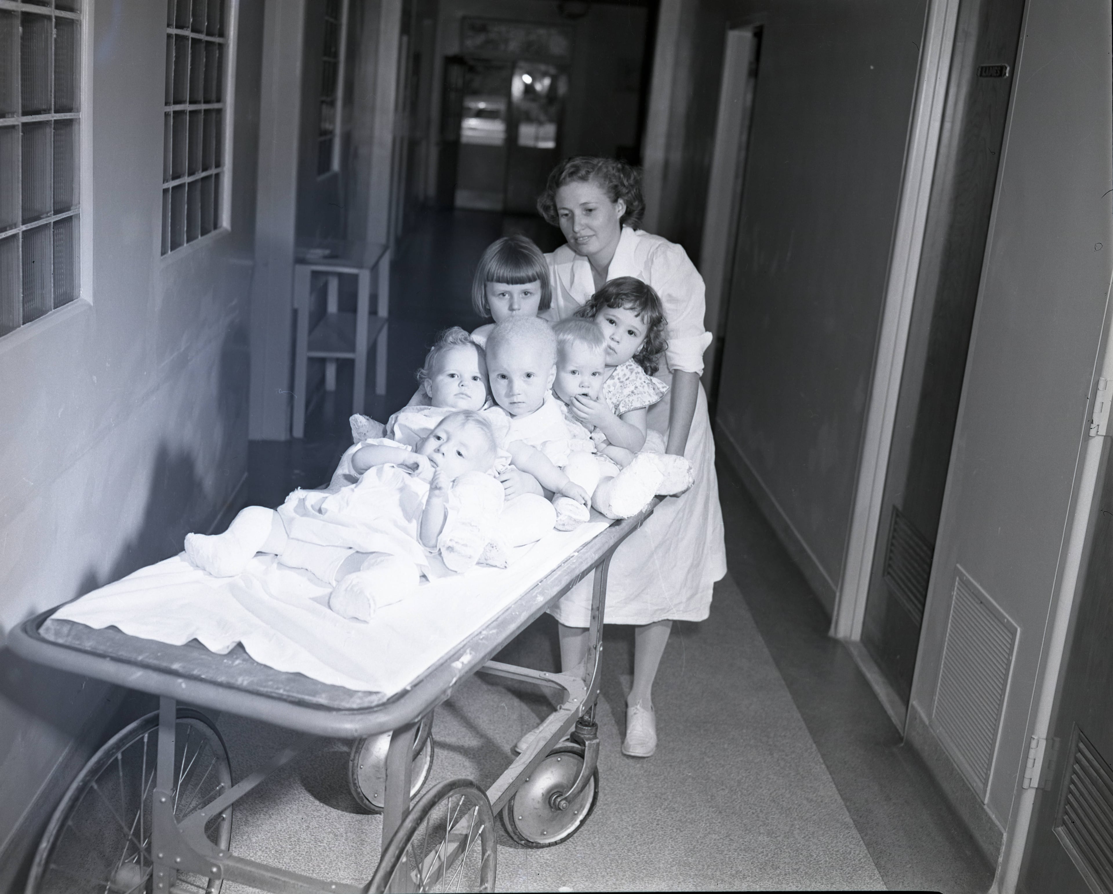 Nurse moving children on a gurney, circa 1940s. AJC file.
