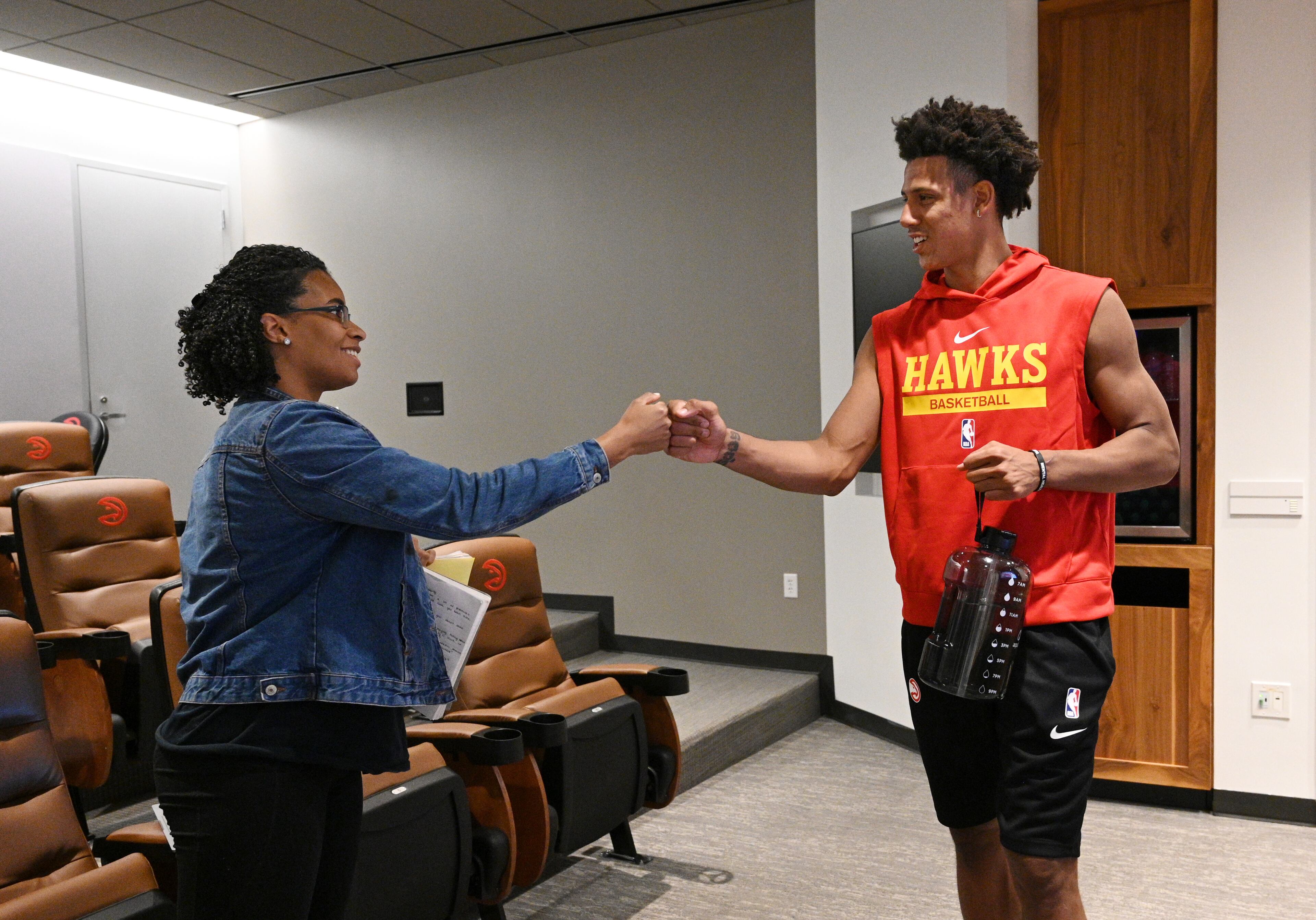 Atlanta Hawks forward Jalen Johnson, who did not make the trip, reacts as he watches a preseason game against Milwaukee Bucks in Abu Dabi with AJC beat reporter Lauren Williams at the team's training facility on Thursday, Oct. 6, 2022. (Hyosub Shin / Hyosub.Shin@ajc.com)