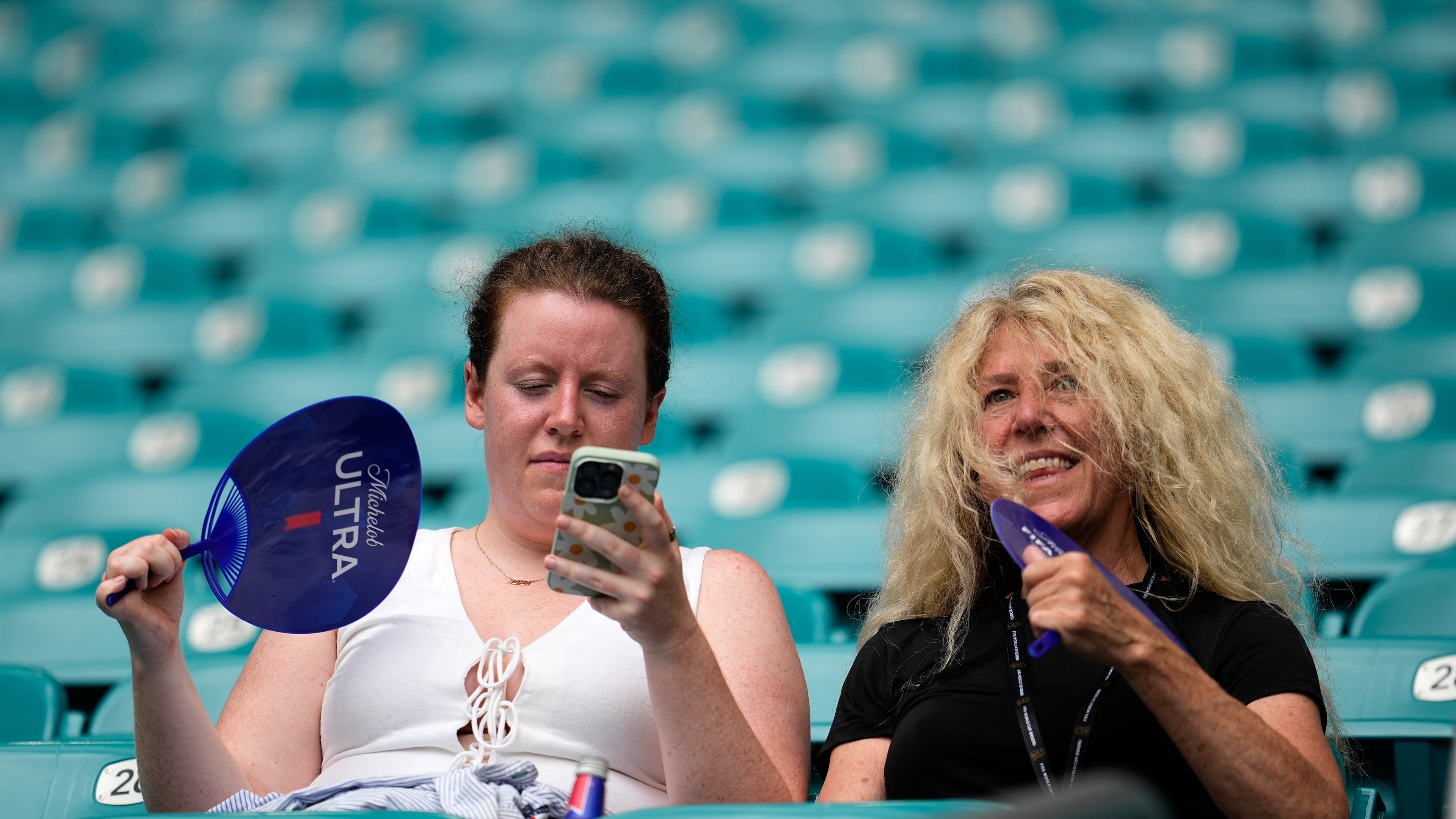 Spectators fan themselves before the World Cup quarterfinal soccer match between Norway and England in Miami Gardens, Fla., Saturday, July 11, 2026. (AP Photo/George Walker IV)