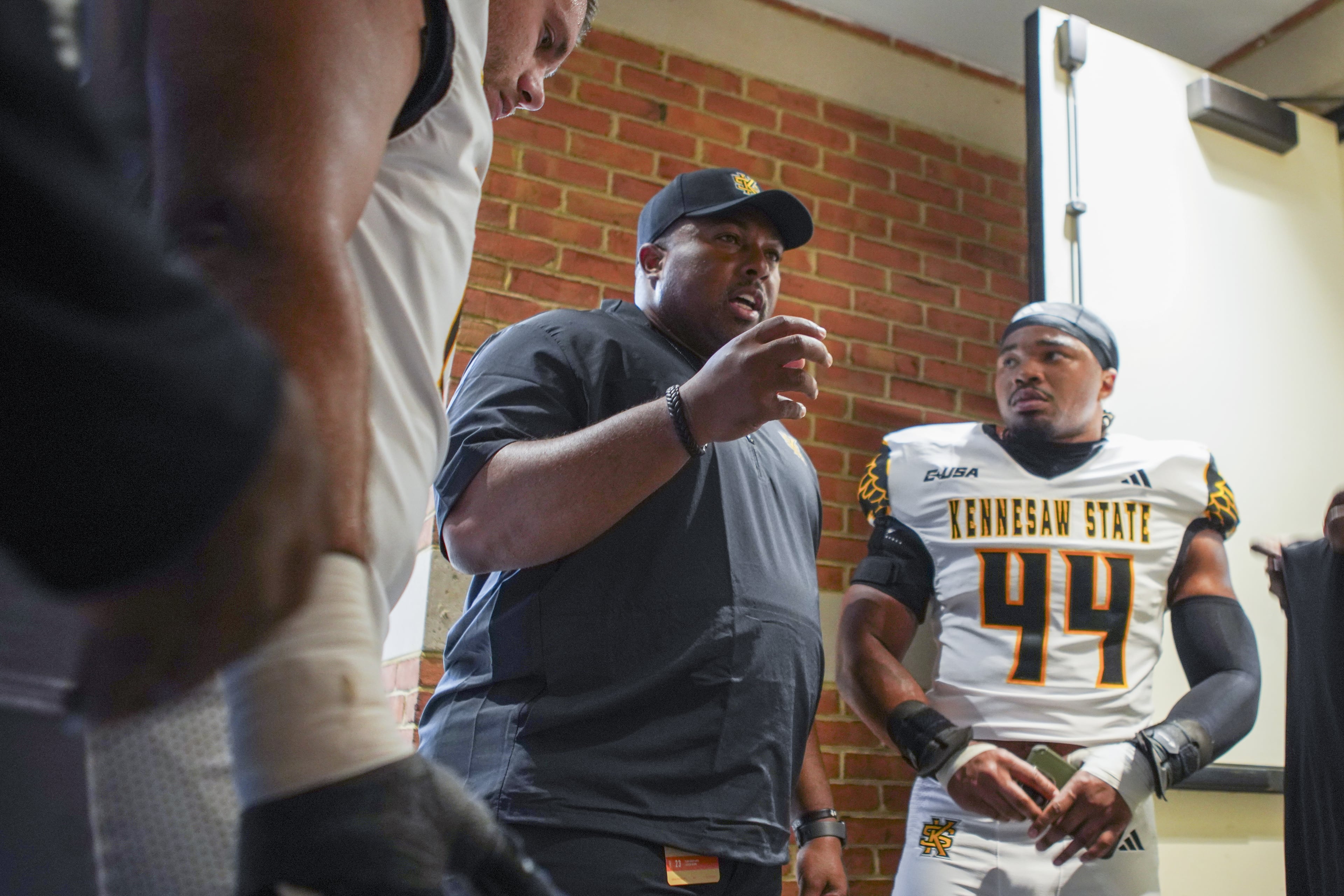 Baron Hopson (right) listens to coach Jerry Mack's instructions before Kennesaw State's season opener at Wake Forest. (Kennesaw State Athletics)