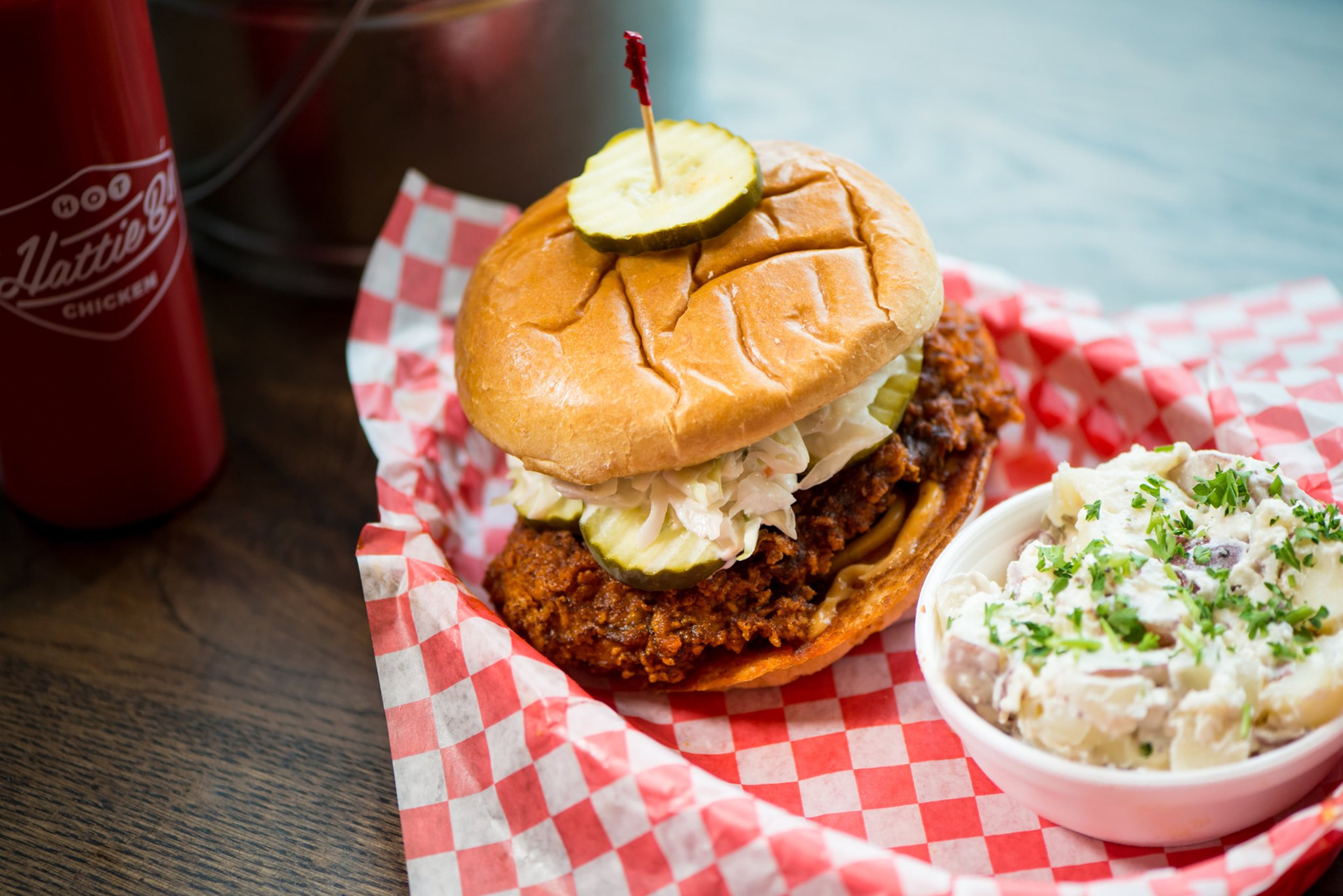 Hattie B’s Hot Chicken sandwich with fried chicken breast, cole slaw, Nashville comeback sauce, kosher pickle, with red skin potato salad. Photo credit- Mia Yakel.