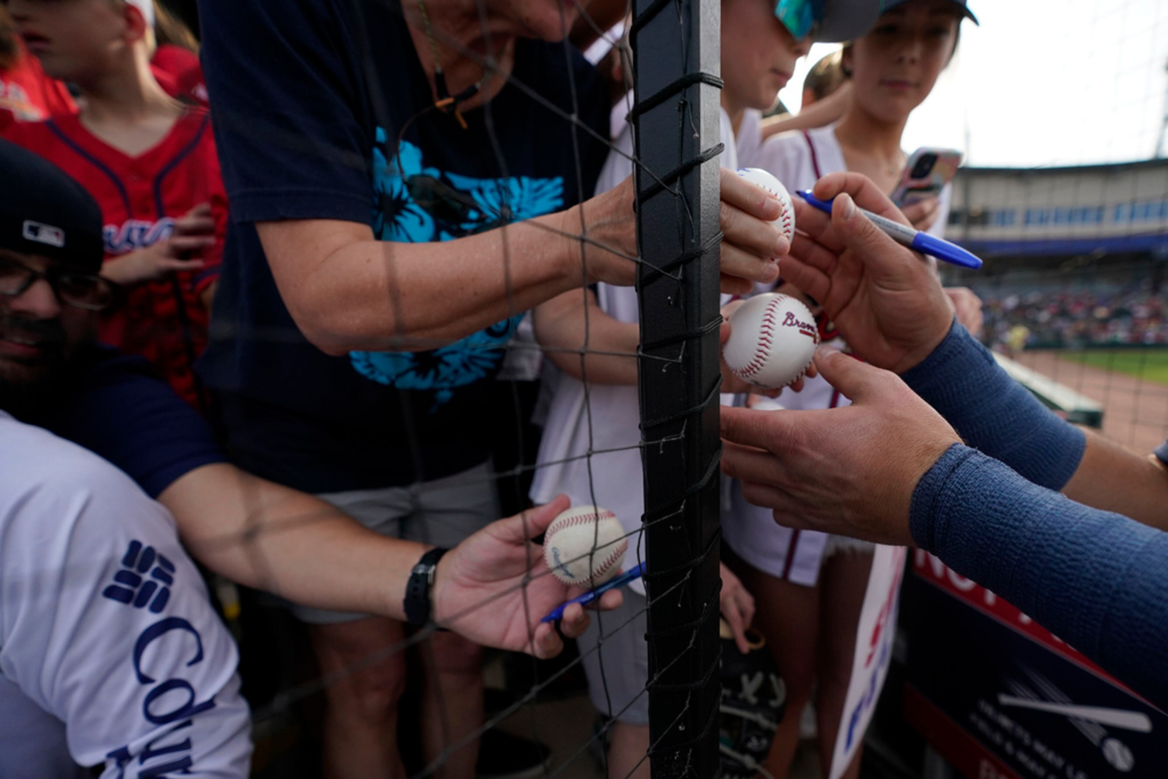 Atlanta Braves third baseman Austin Riley signs autographs for fans before a spring training baseball game against the Philadelphia Phillies in North Port, Fla., Saturday, March 18, 2023. (AP Photo/Gerald Herbert)