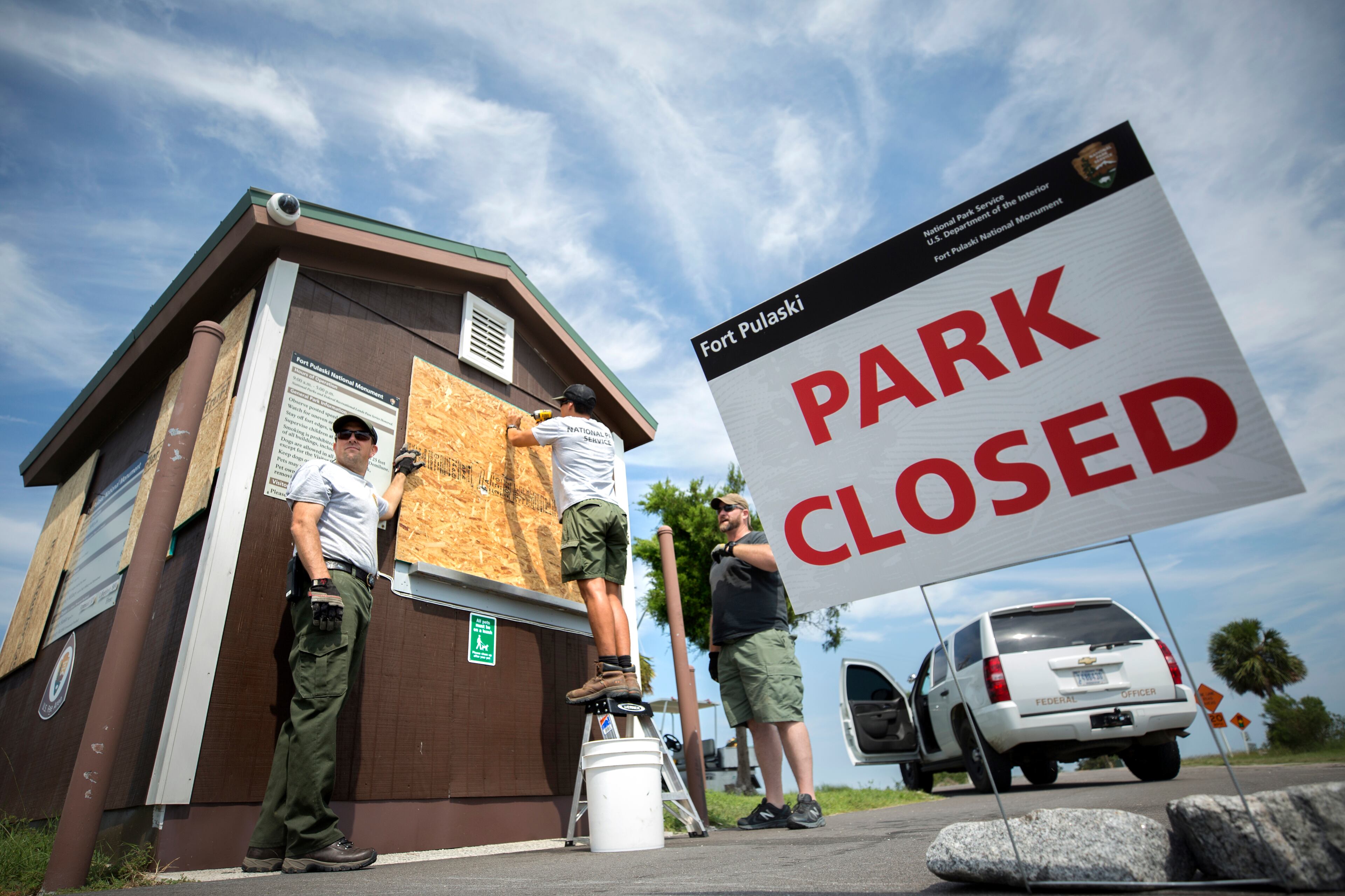 National Park Service employees screw in particle board to the secure the windows of the entrance station at Fort Pulaski National Monument near Tybee Island, Ga., Friday, Sept., 8, 2017, before Hurricane Irma is forecast to hit the area early next week. (Stephen B. Morton for The Atlanta Journal Constitution)