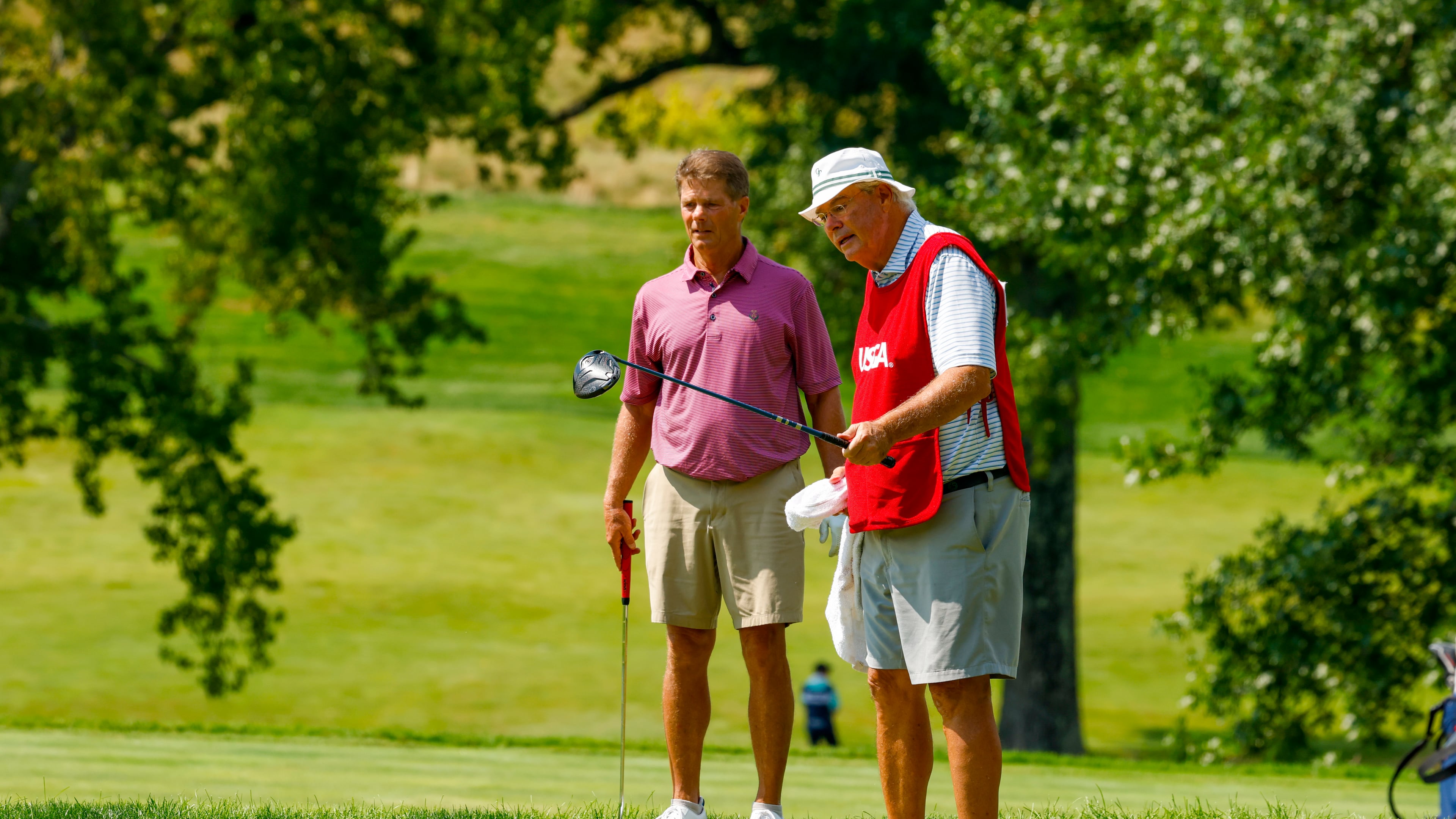 Jack Larkin Sr. (right) and his caddie discuss his putt line on the 15th hole during the round of 64 of the 2026 U.S. Senior Amateur at Baltimore Country Club (East Course) in Lutherville, Md. on Monday, Aug. 31, 2026. (Jason E. Miczek/USGA)