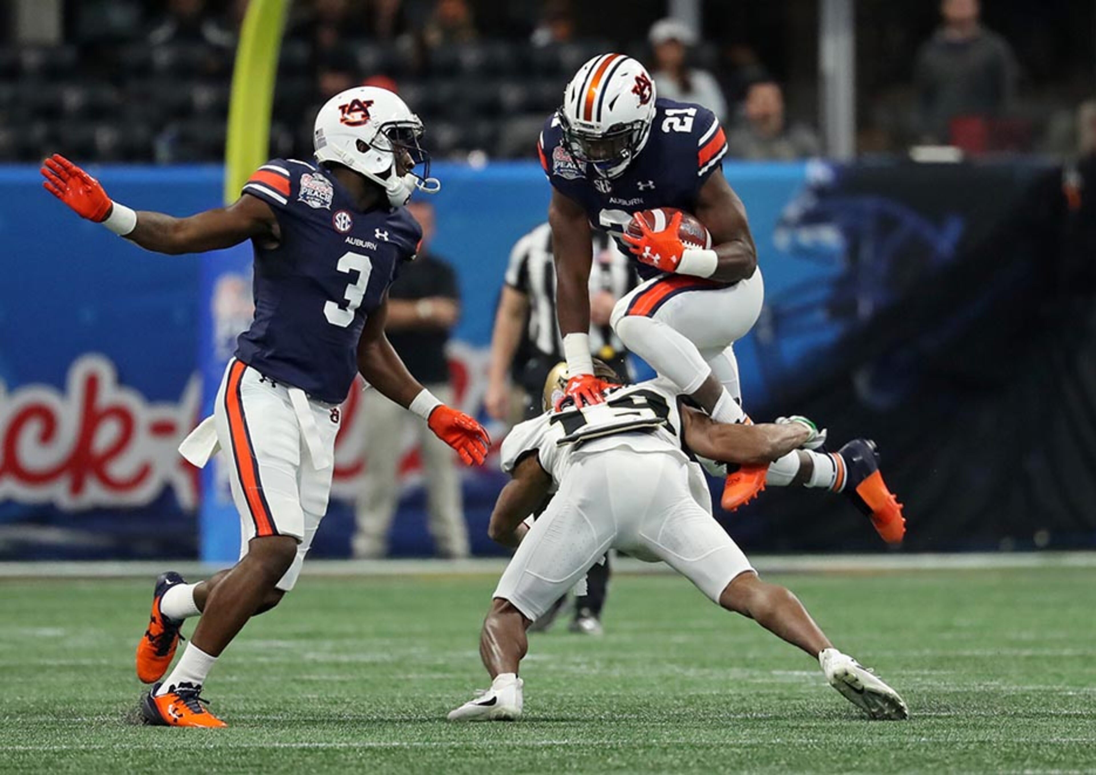 Auburn Tigers running back Kerryon Johnson (21) tries to hurdle UCF Knights defensive back Mike Hughes (19) during the first quarter of the Chick-fil-A Peach Bowl Monday, Jan. 1, 2018, at Mercedes-Benz Stadium in Atlanta.