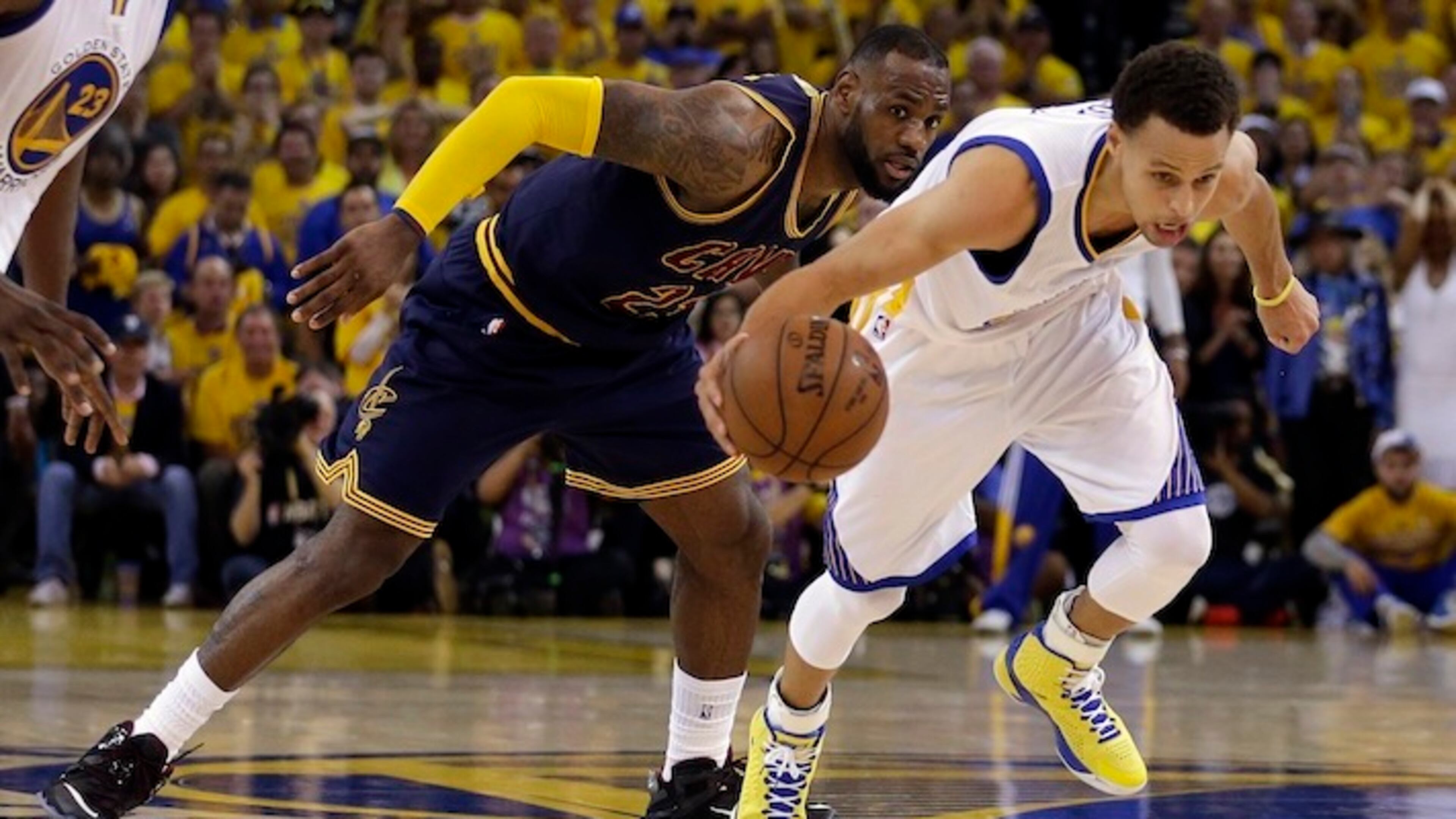 In this June 7, 2015 file photo, Cleveland Cavaliers forward LeBron James (23) watches as Golden State Warriors guard Stephen Curry dribbles during the second half of Game 2 of basketball's NBA Finals in Oakland, Calif. For months, the Cavaliers' megastar has lived slightly under the radar, if that's even possible for one of the world's most famous and recognizable athletes. While Stephen Curry rained 3-pointers as the new face of the NBA, the Golden State Warriors hunted down history and Kobe Bryant took his final bows, James remained in the background awaiting his turn. (AP Photo/Ben Margot, File)