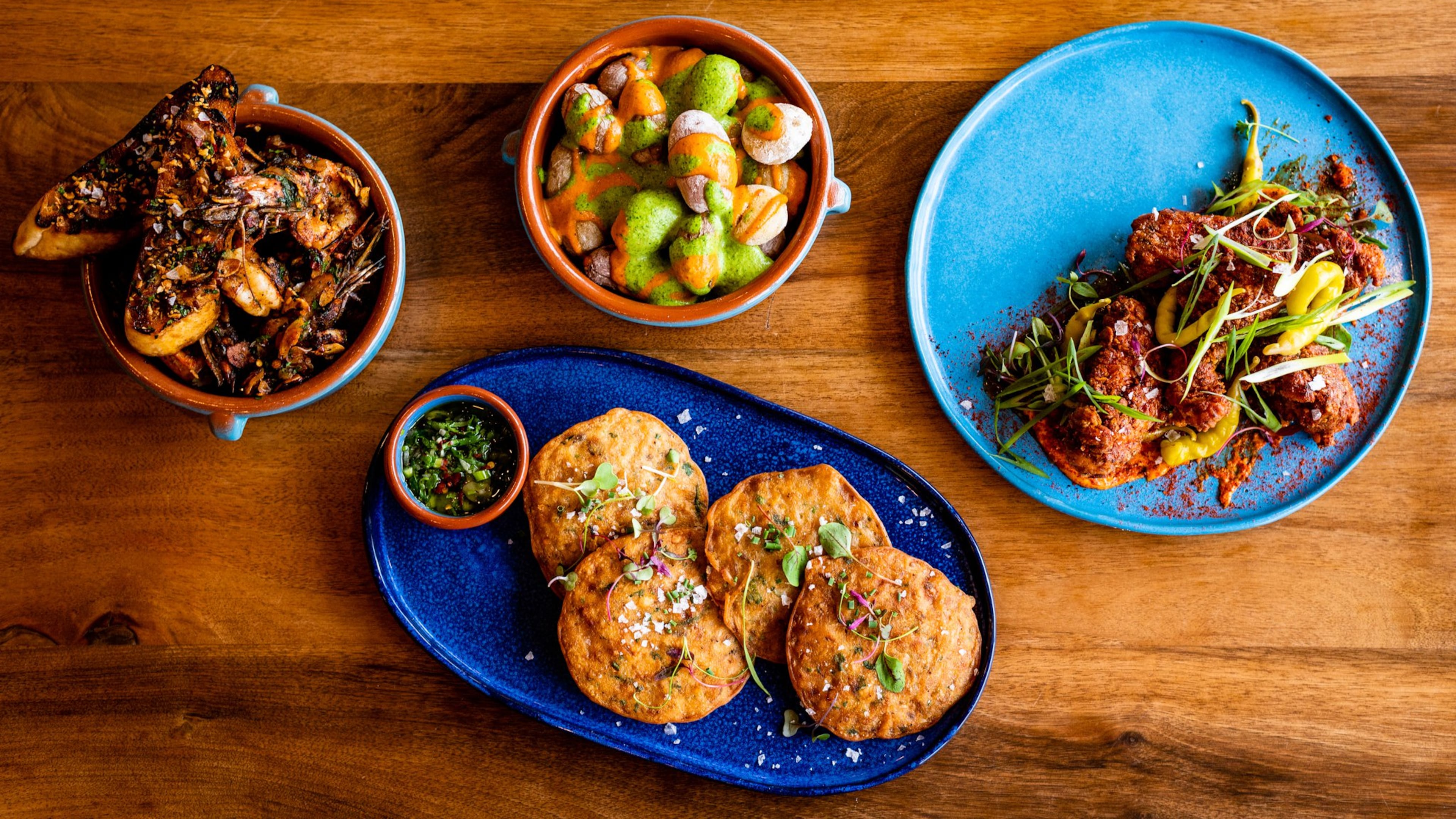 Buena Vida serves up plenty of tapas, including (clockwise from upper left): Gambas al Ajillo, Canary Island Wrinkly Potatoes, Crispy Pimentón Chicken and Torticas de Camaron. CONTRIBUTED BY HENRI HOLLIS