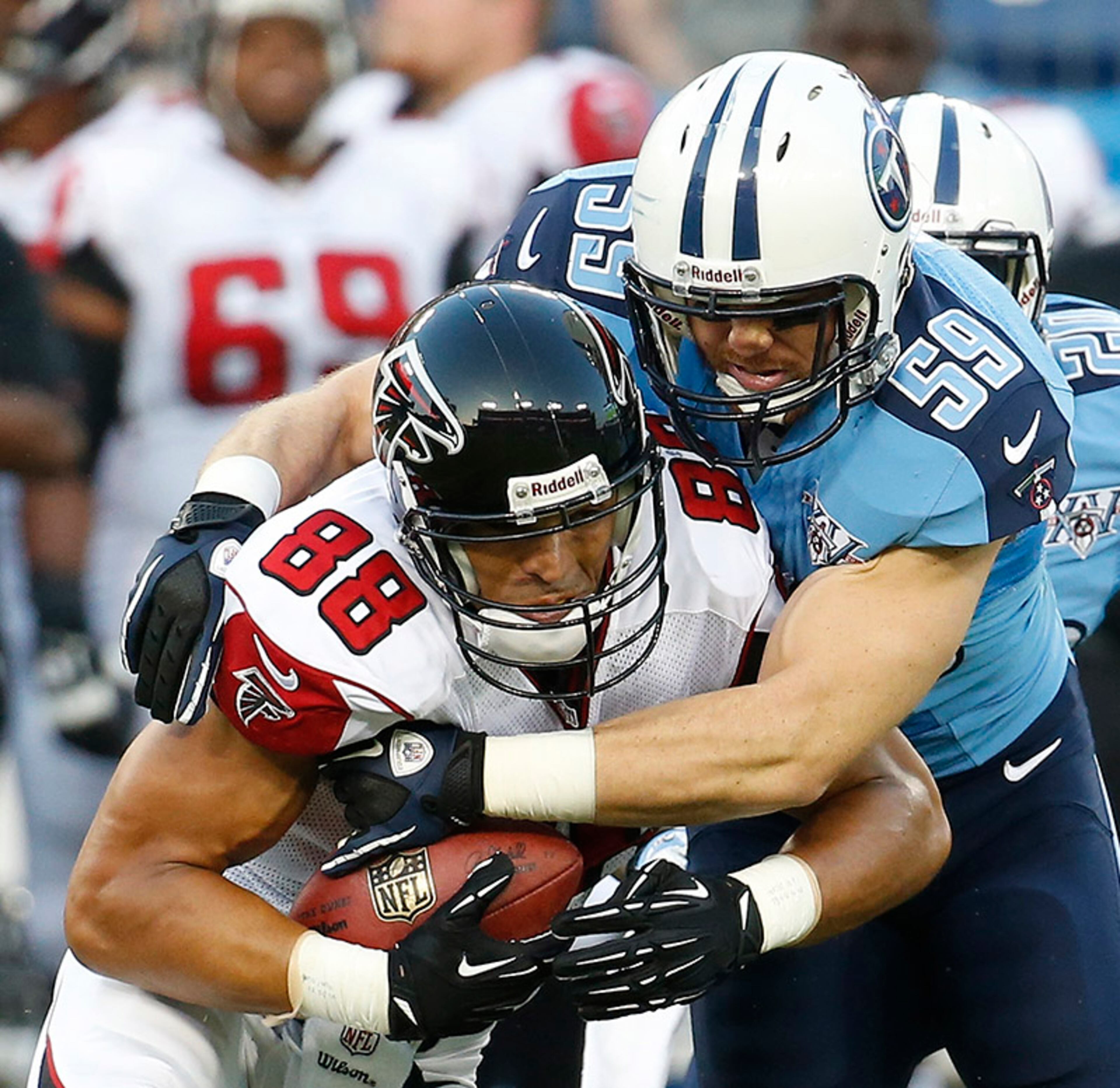 Falcons tight end Tony Gonzalez (88) is hit by Titans middle linebacker Tim Shaw (59).