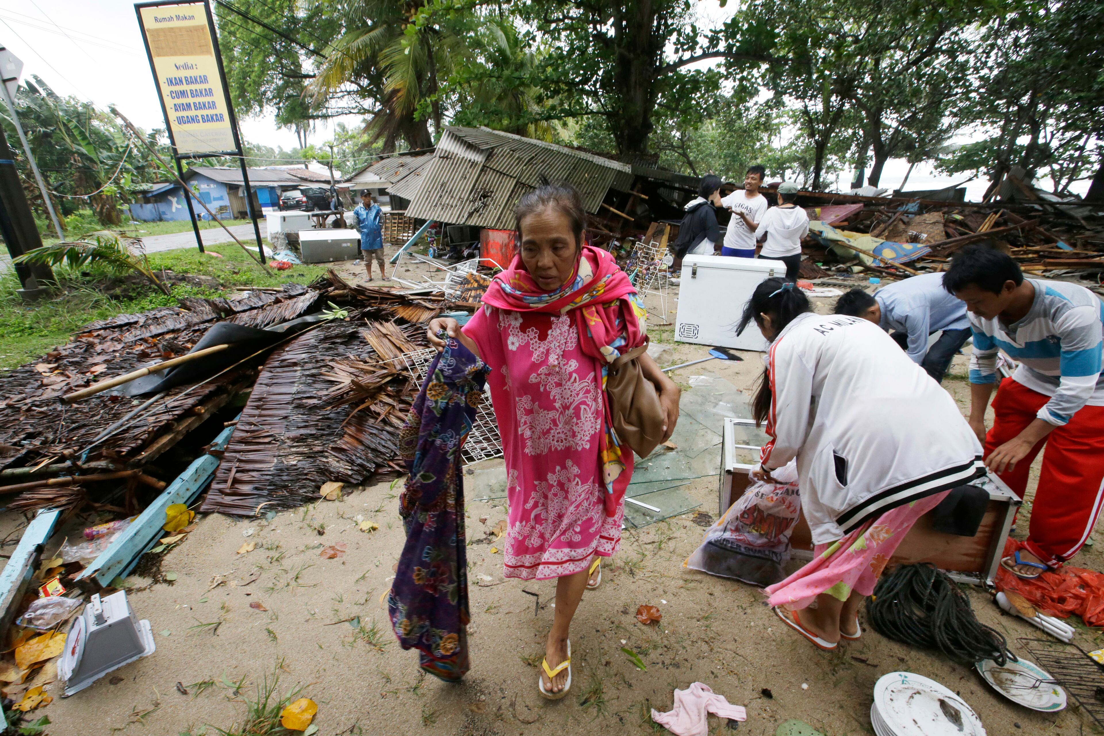 A women inspects her house which was damaged by Saturday's tsunami in Indonesia.