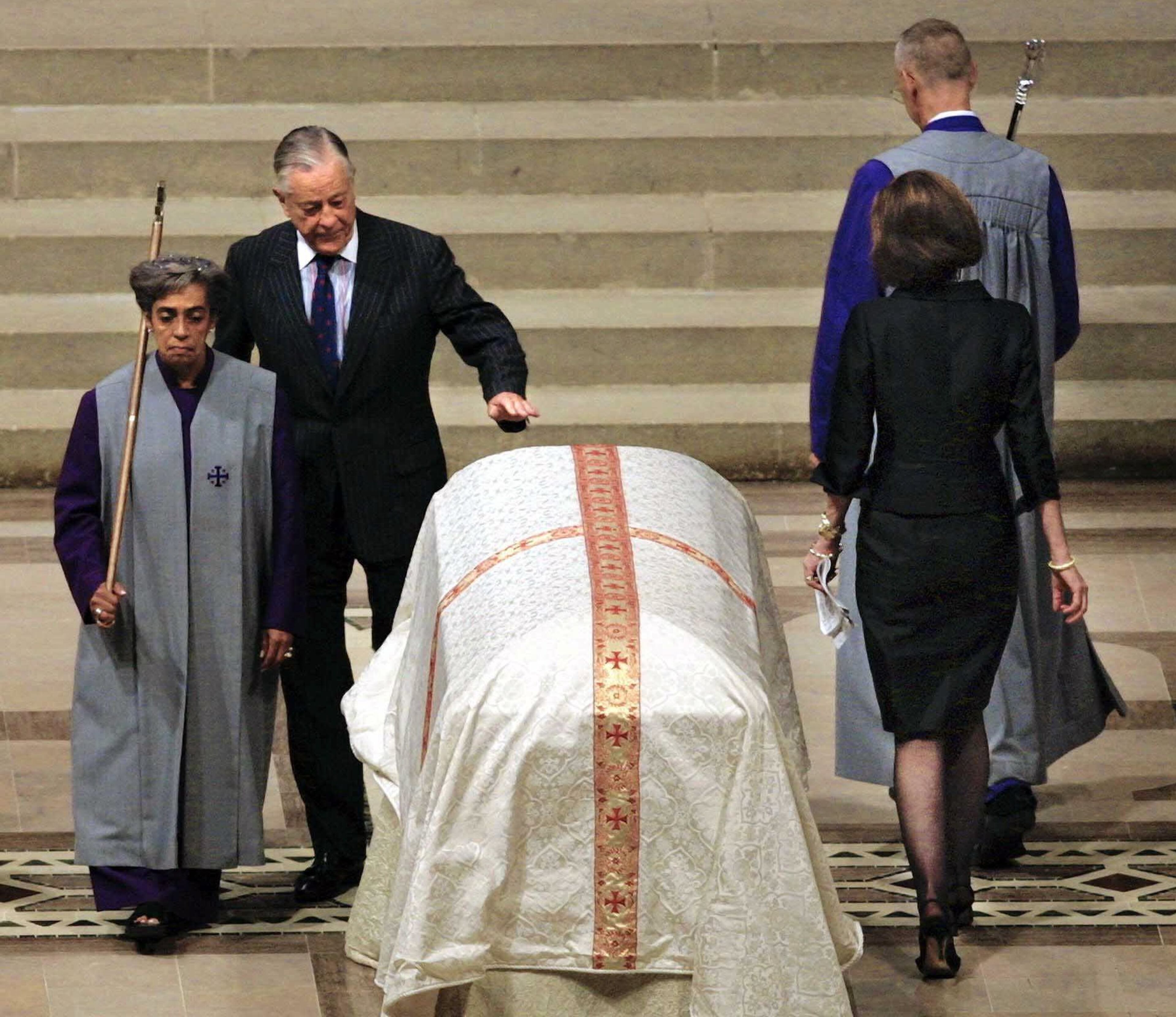 Washington Post Vice President Ben Bradlee, left, touches Katharine Graham's casket as he passes after speaking at funeral service, in Washington, Monday July 23, 2001. Mrs. Graham, who served as chairman of the Washington Post Co. for two decades, died last Tuesday at 84 from injuries in a fall in Sun Valley, Idaho. (AP Photo/Robert Reeder, Pool)
