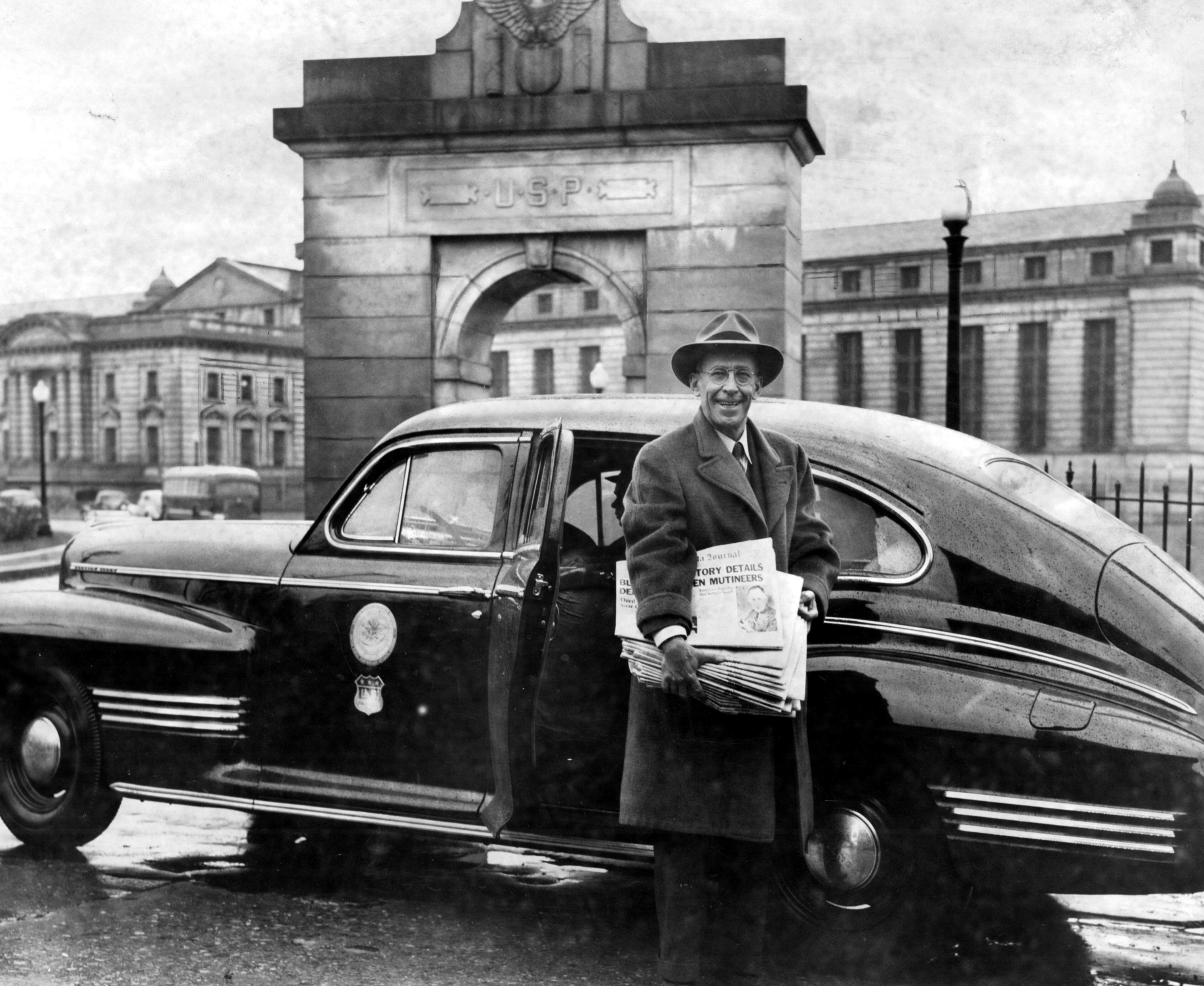 BLAKE ARRIVES AT PEN WITH 'GRIEVANCE' STORY. - With twice as many copies as he promised the barricaded convicts at the Atlanta Federal Penitentiary Morgan Blake prepares to enter the prison Thursday to distribute the edition which carries his story airing the grievances of the convicts, which caused them to mutiny in the segregation building. - Journal Photo (1944)