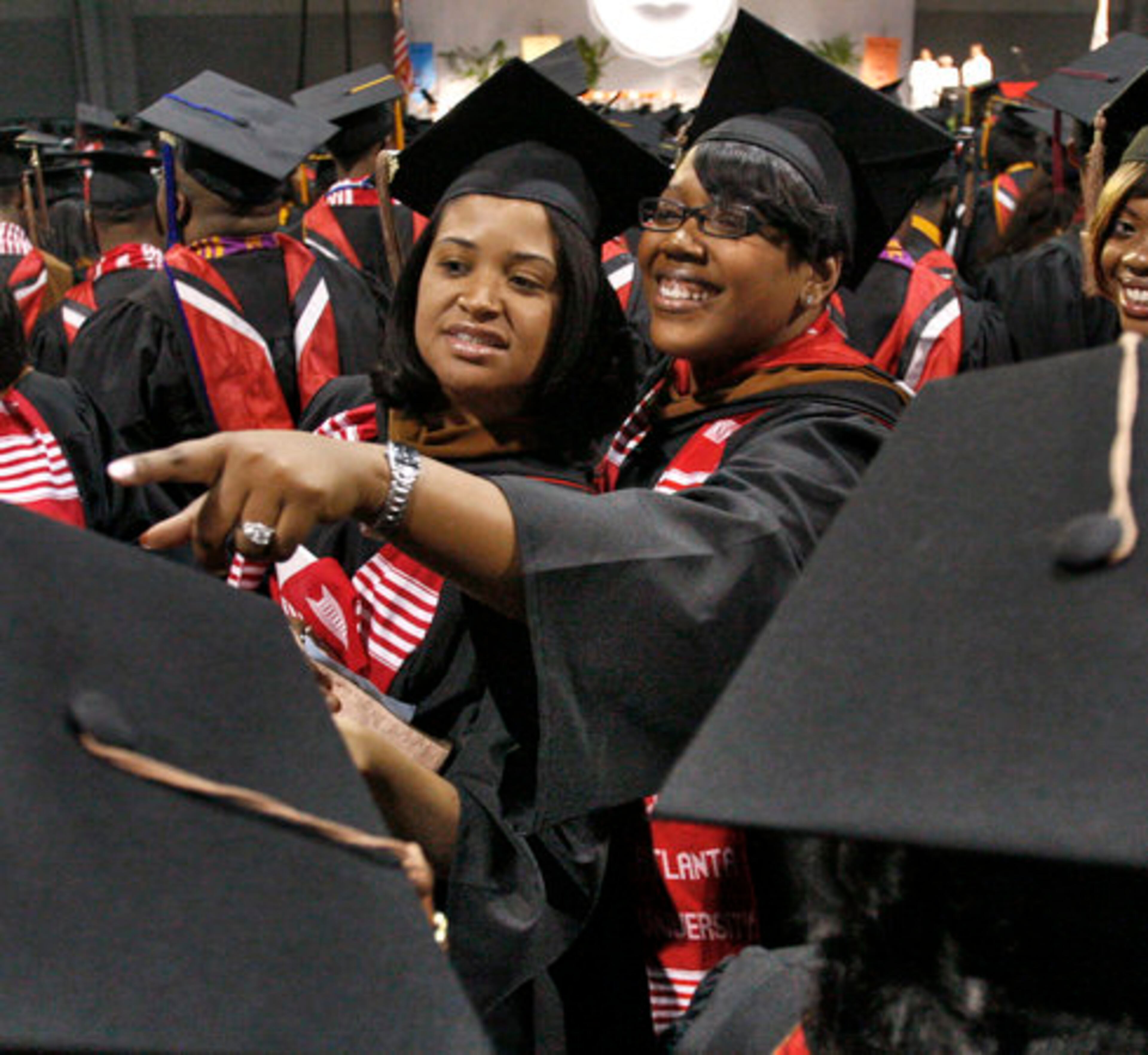 Shannon O'Riley from Shreveport, La., (left) and Trasha Collins from Miami look for family and friends Monday at Clark Atlanta University's graduation ceremony at the Georgia World Congress Center.