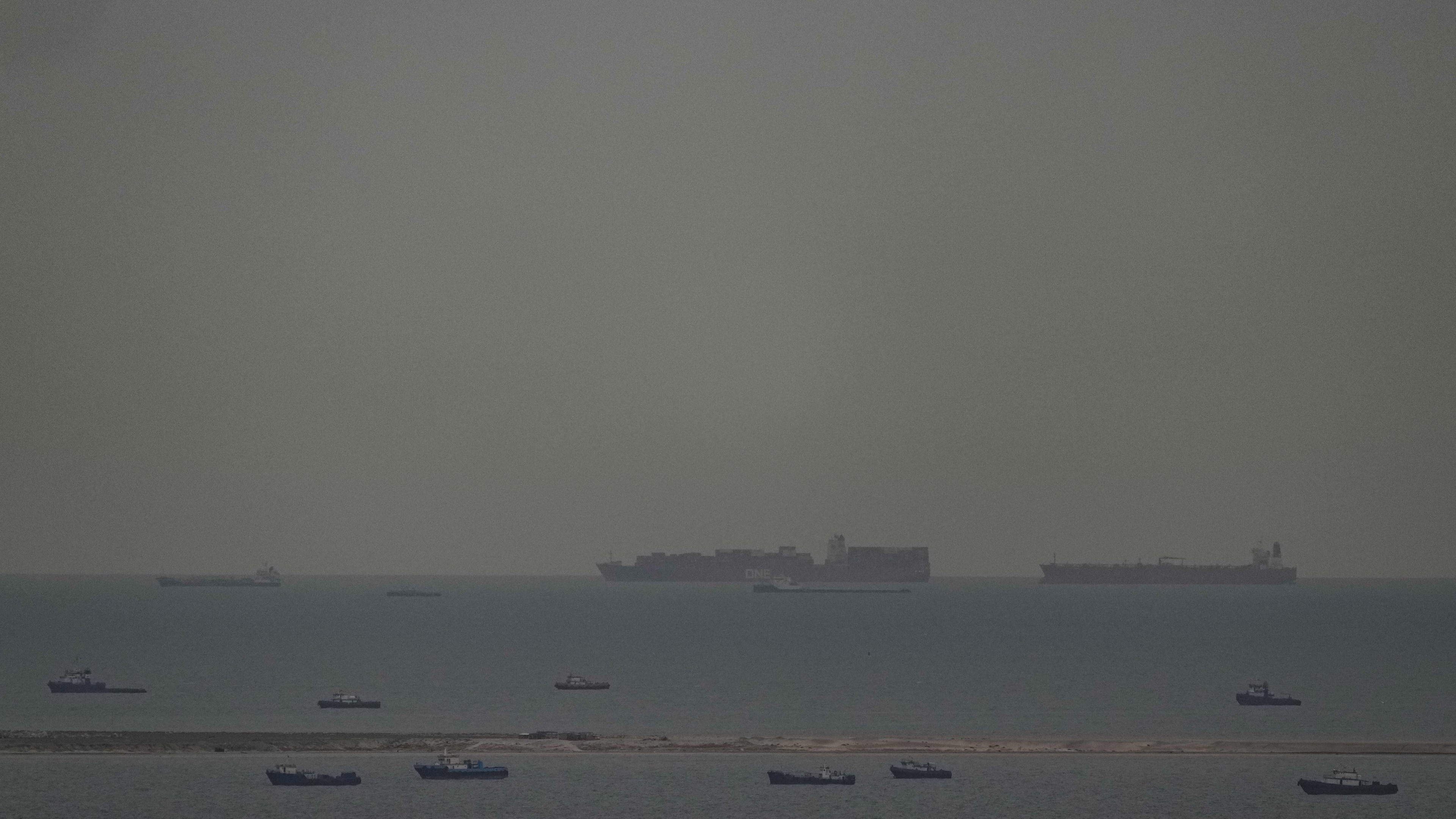 Fishing boats dot the sea as cargo ships, in the background, sail through the Arabian Gulf toward the Strait of Hormuz off the United Arab Emirates, Friday, March 27, 2026. (AP Photo)