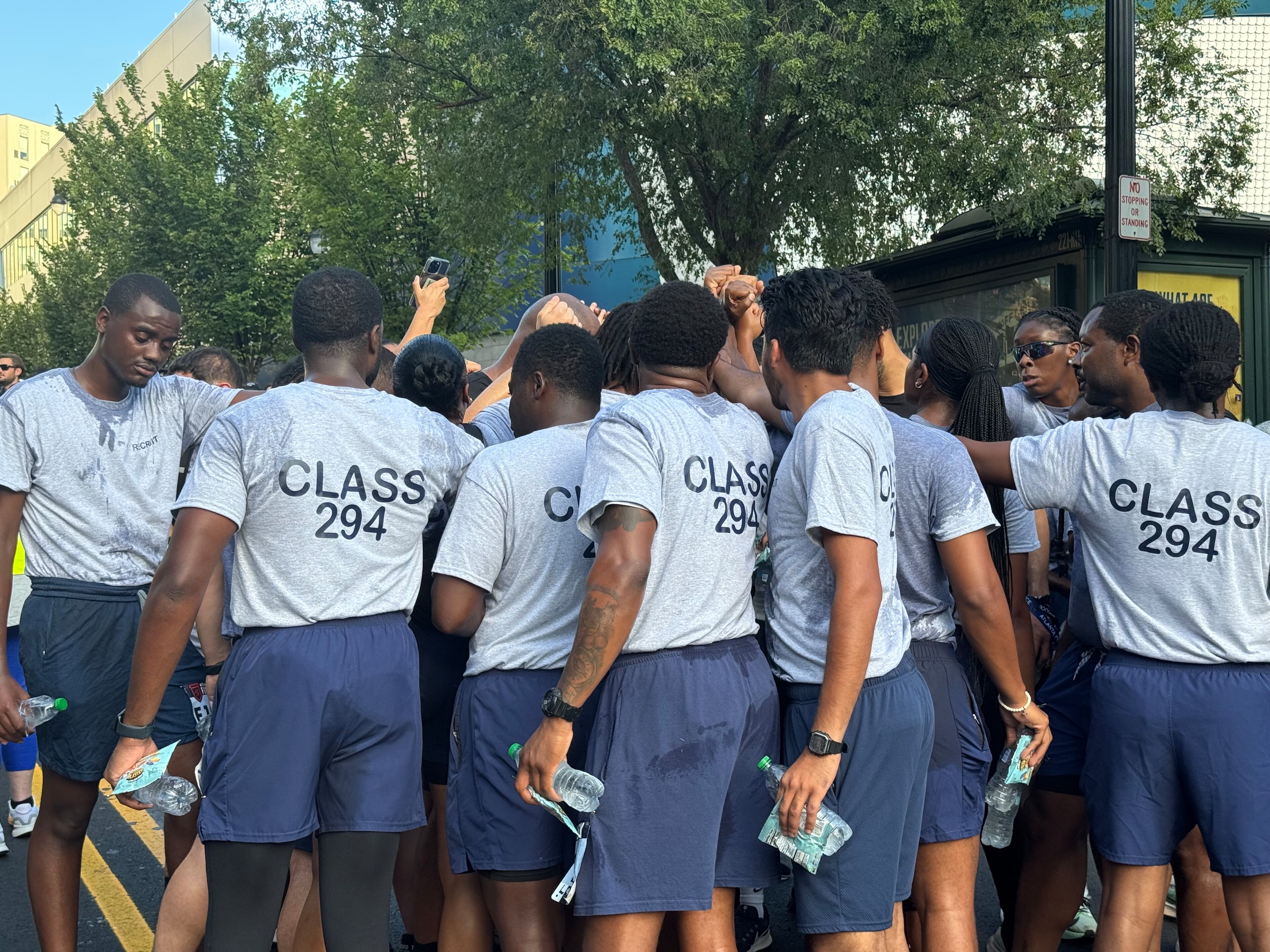Atlanta Police Department recruits huddle after finishing the Atlanta's Finest 5K race. Nearly 1,700 people signed up to run in the race to honor Atlanta law enforcement and public safety officials. (Caleb Groves/AJC)
