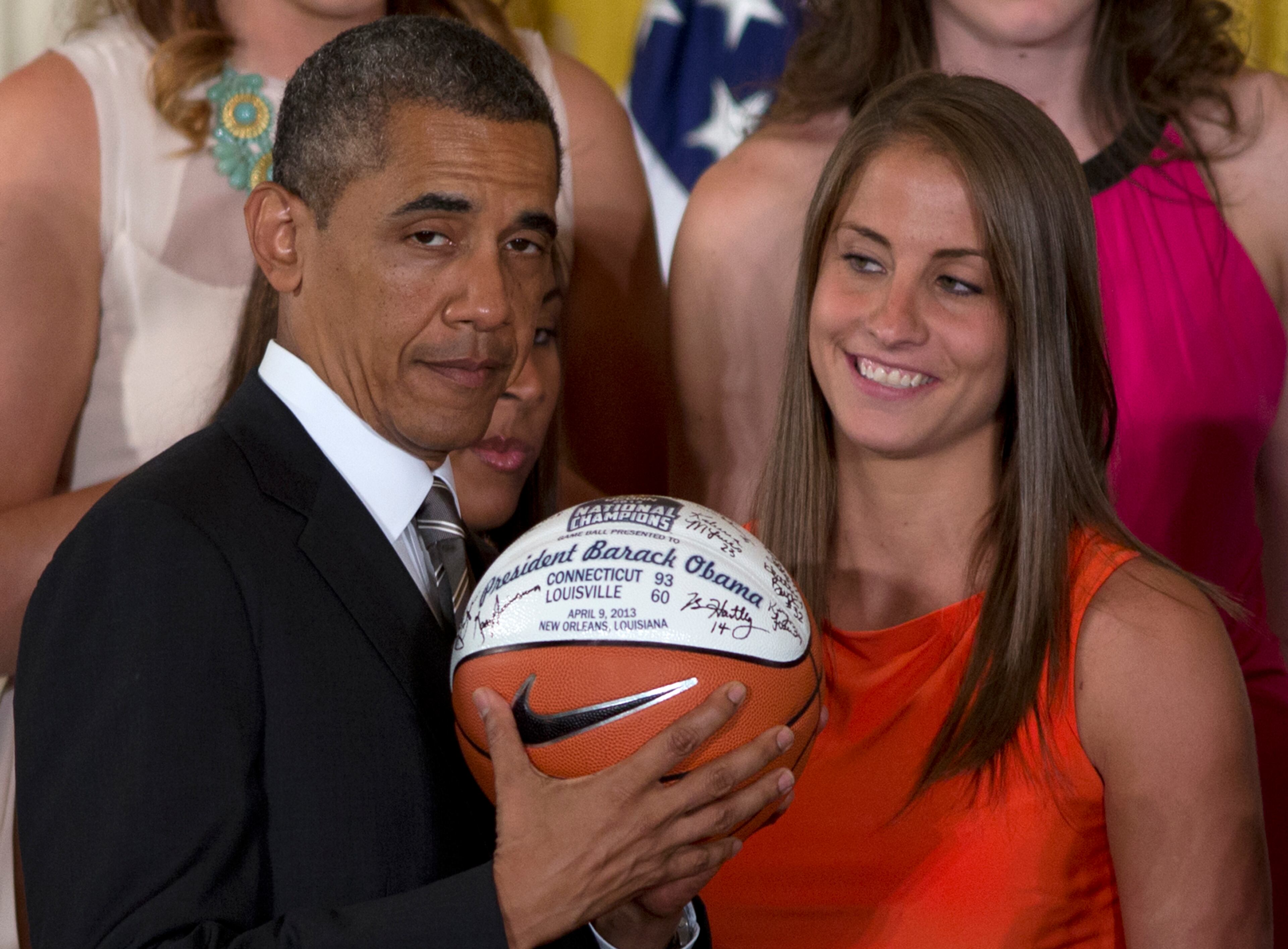 University of Connecticut Huskies basketball guard Caroline Doty looks at President Barack Obama as he shows the signed basketball she just gave him during a ceremony in the East Room of the White House in Washington, Wednesday, July 31, 2013, where the president honored the 2013 NCAA Women's Basketball Champion team, the University of Connecticut Huskies. (AP Photo/Carolyn Kaster)