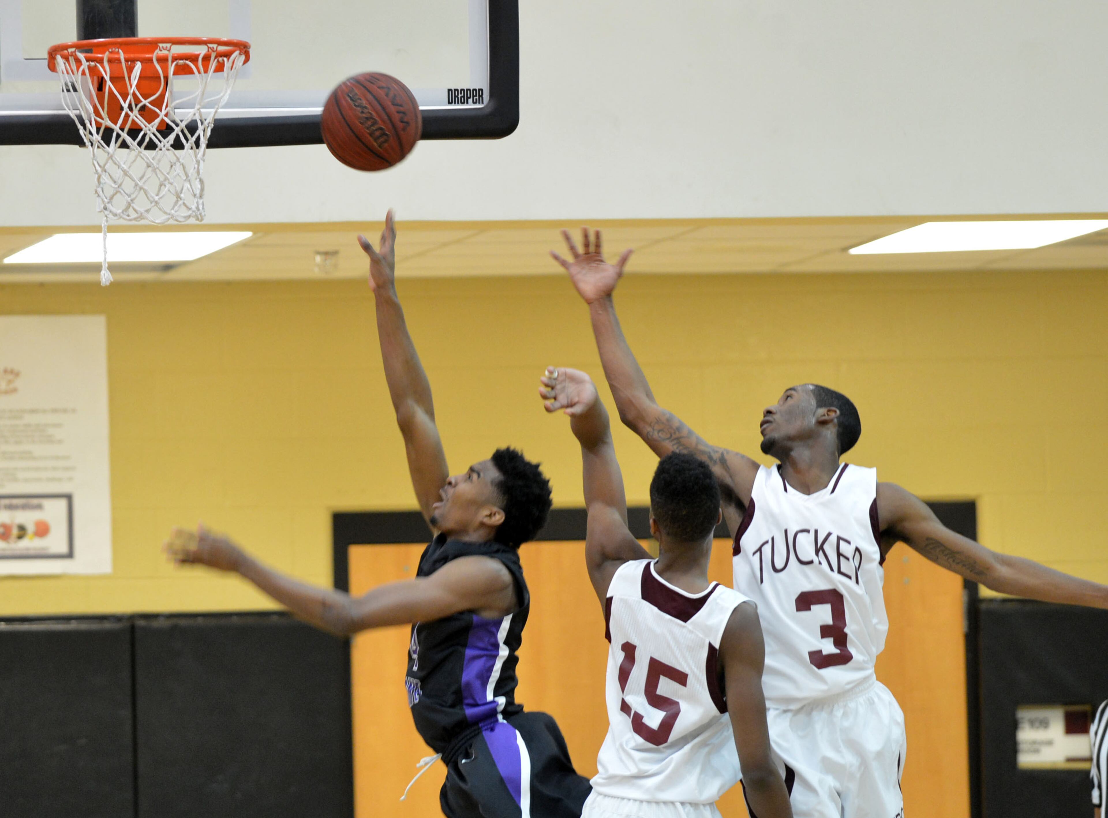 Miller Grove's Raylon Richardson goes up for the shot against Tucker's Tyrell Thomas (15) and Kehel Assing (3) during action in the first half of the Miller Grove at Tucker HS boys basketball game at Tucker HS on Friday, Jan. 17, 2014. Miller Grove's boys team has won five consecutive championships in the state's second-highest classification. The Wolverines, led by Tulane signee Keith Pinckney, are ranked No. 1 again this season.