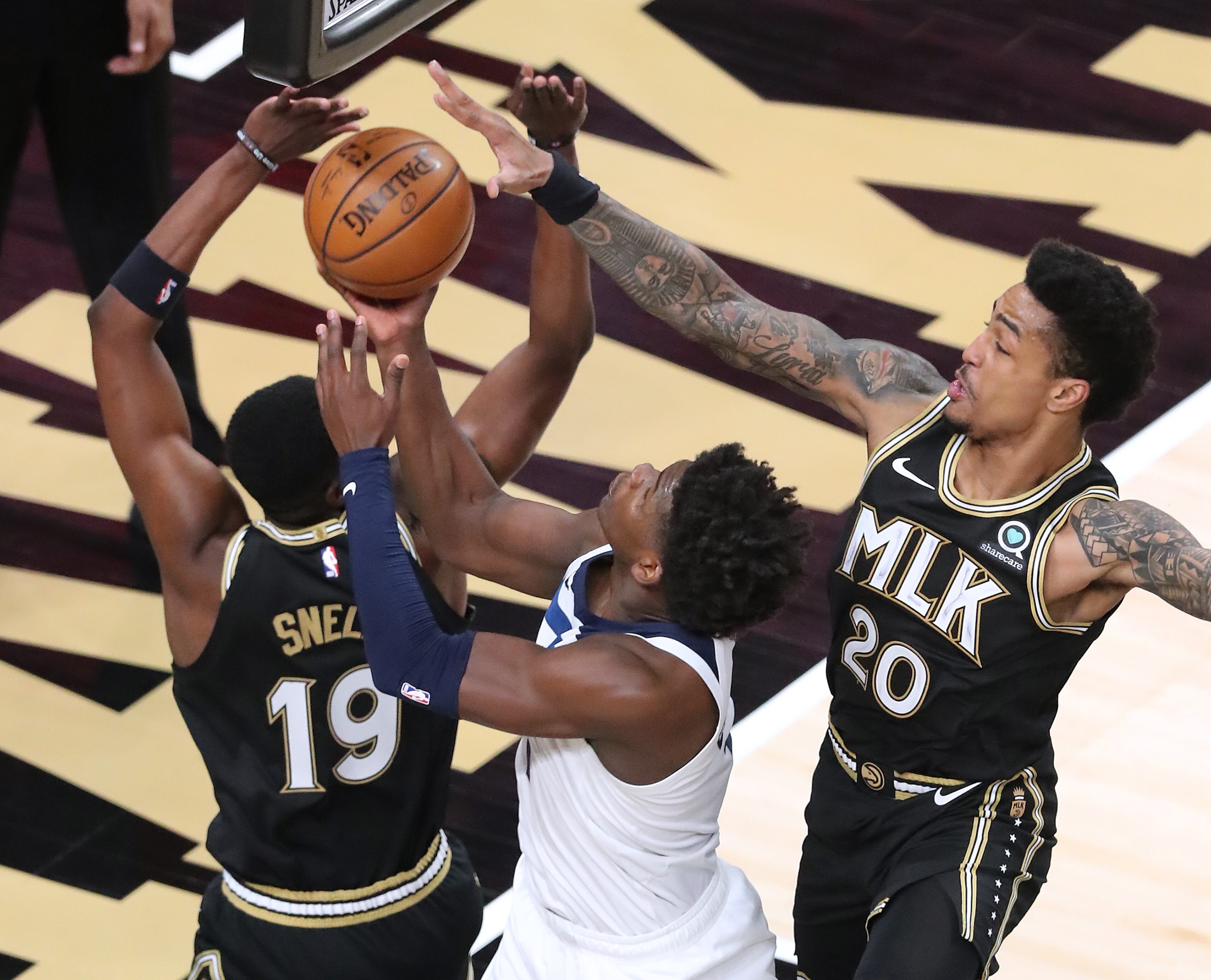 Hawks guard Tony Snell (left) and forward John Collins defend against Minnesota Timberwolves guard Anthony Edwards blocking his shot during the MLK Day Unity game Monday, Jan. 18, 2021, at State Farm Arena in Atlanta. (Curtis Compton / Curtis.Compton@ajc.com)