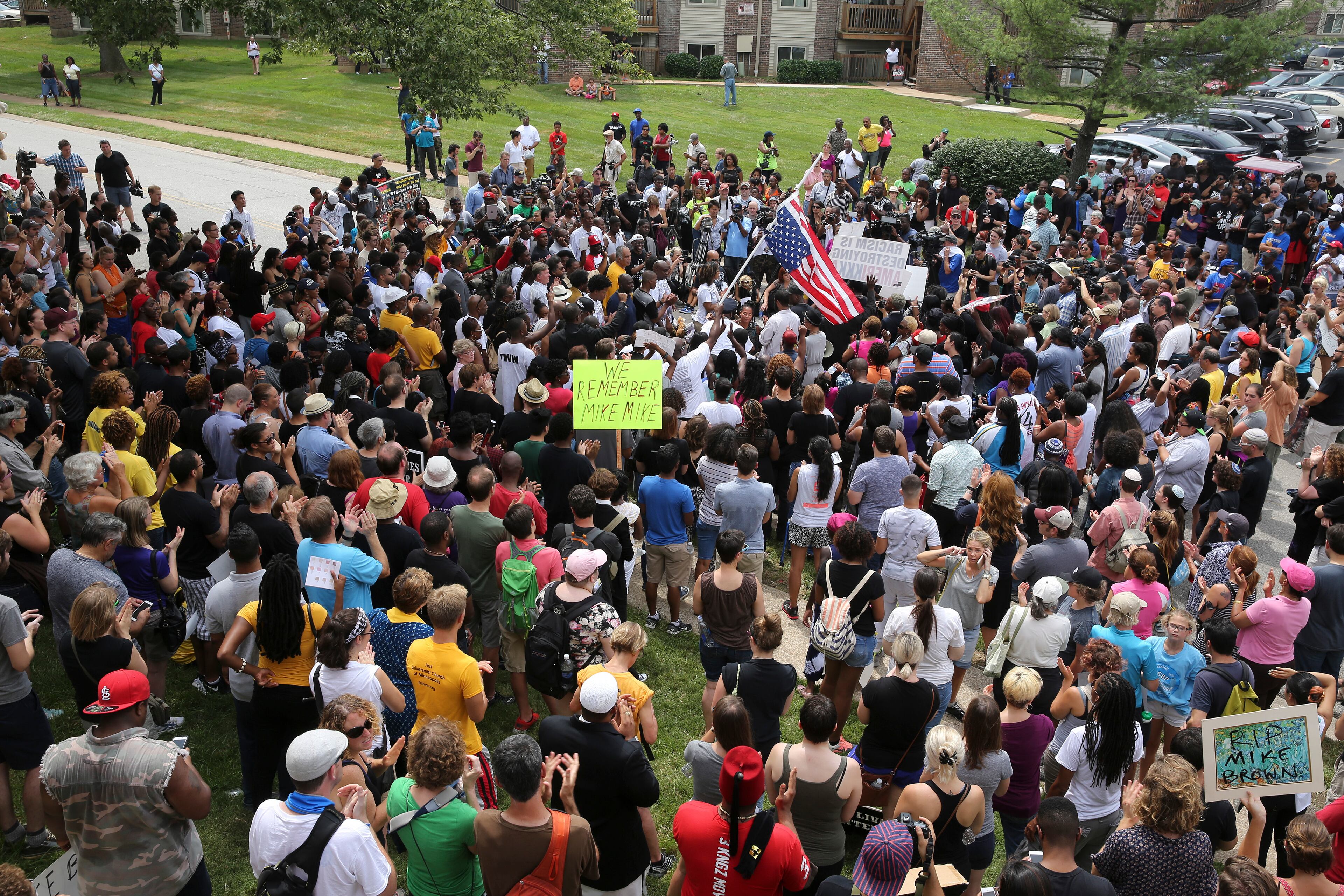 People gather on Canfield Drive on the first anniversary of the fatal shooting of Michael Brown by a police officer, in Ferguson, Mo., Aug. 9, 2015. Twelve months since his death in this St. Louis suburb touched off a national protest movement, demonstrators have returned to its streets for a series of commemorations this weekend that are expected to last through Monday. (Richard Perry/The New York Times)