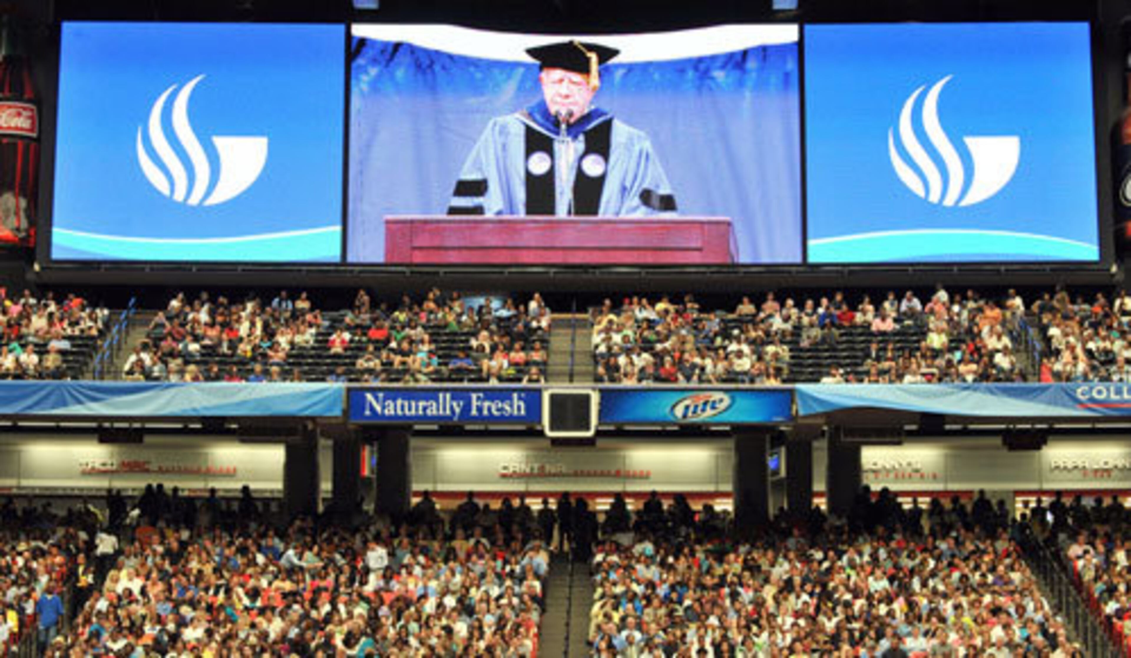 Large screens project the image of former President Carter as he speaks to students.