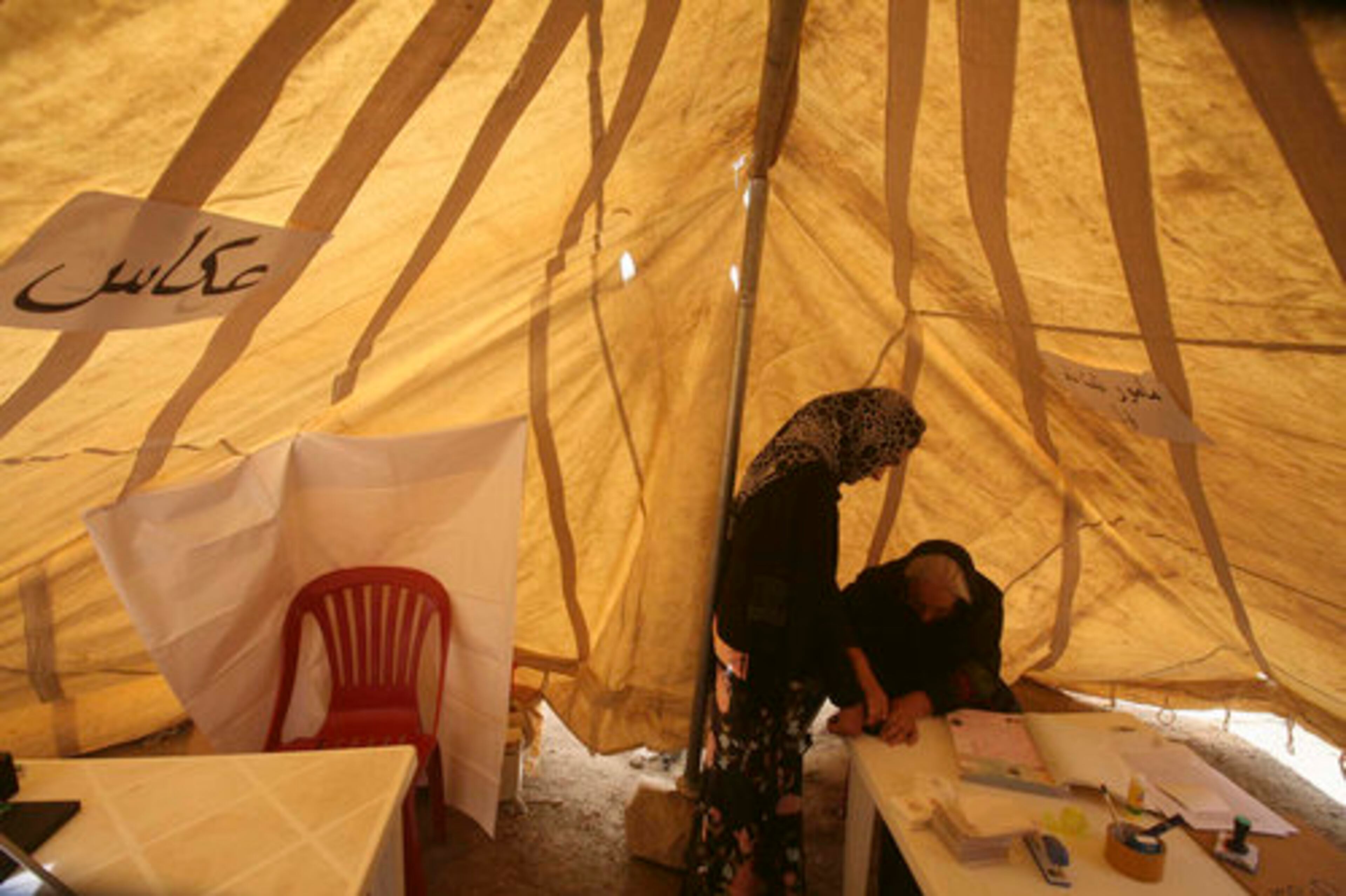 An election official takes the fingerprints of an Afghan woman for her voter identity card at the registration office north of Kabul, Afghanistan, on Monday. Afghanistan began registering voters for next year's presidential polls, an election likely to be the most dangerous and challenging since the Taliban were ousted from power in 2001.