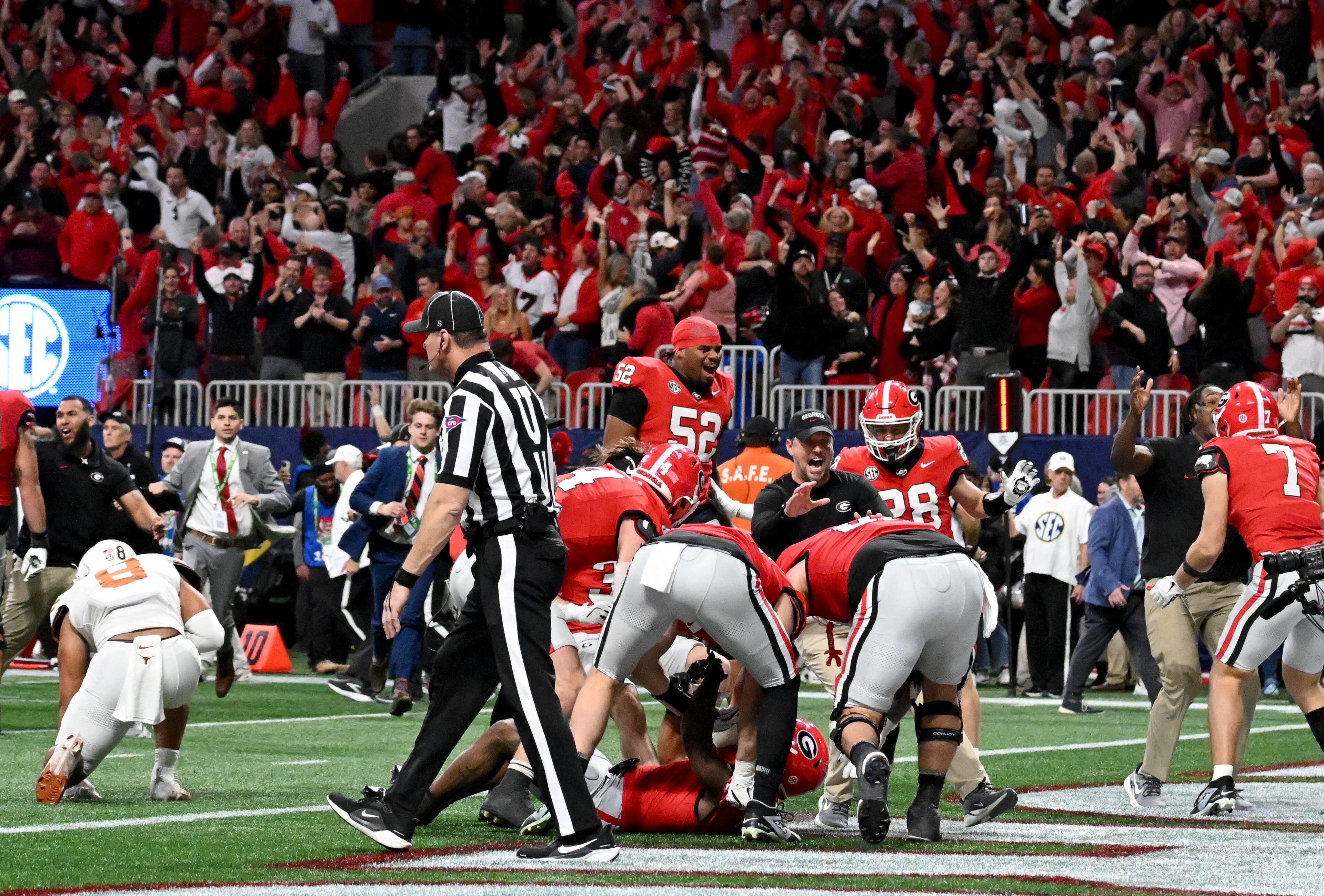 Georgia running back Trevor Etienne (1) is surrounded by teammates after scoring the game winning touchdown in overtime during the SEC Championship football game at the Mercedes-Benz Stadium, Saturday, December 7, 2024, in Atlanta. Georgia won 22-19 over Texas in overtime. (Hyosub Shin / AJC)