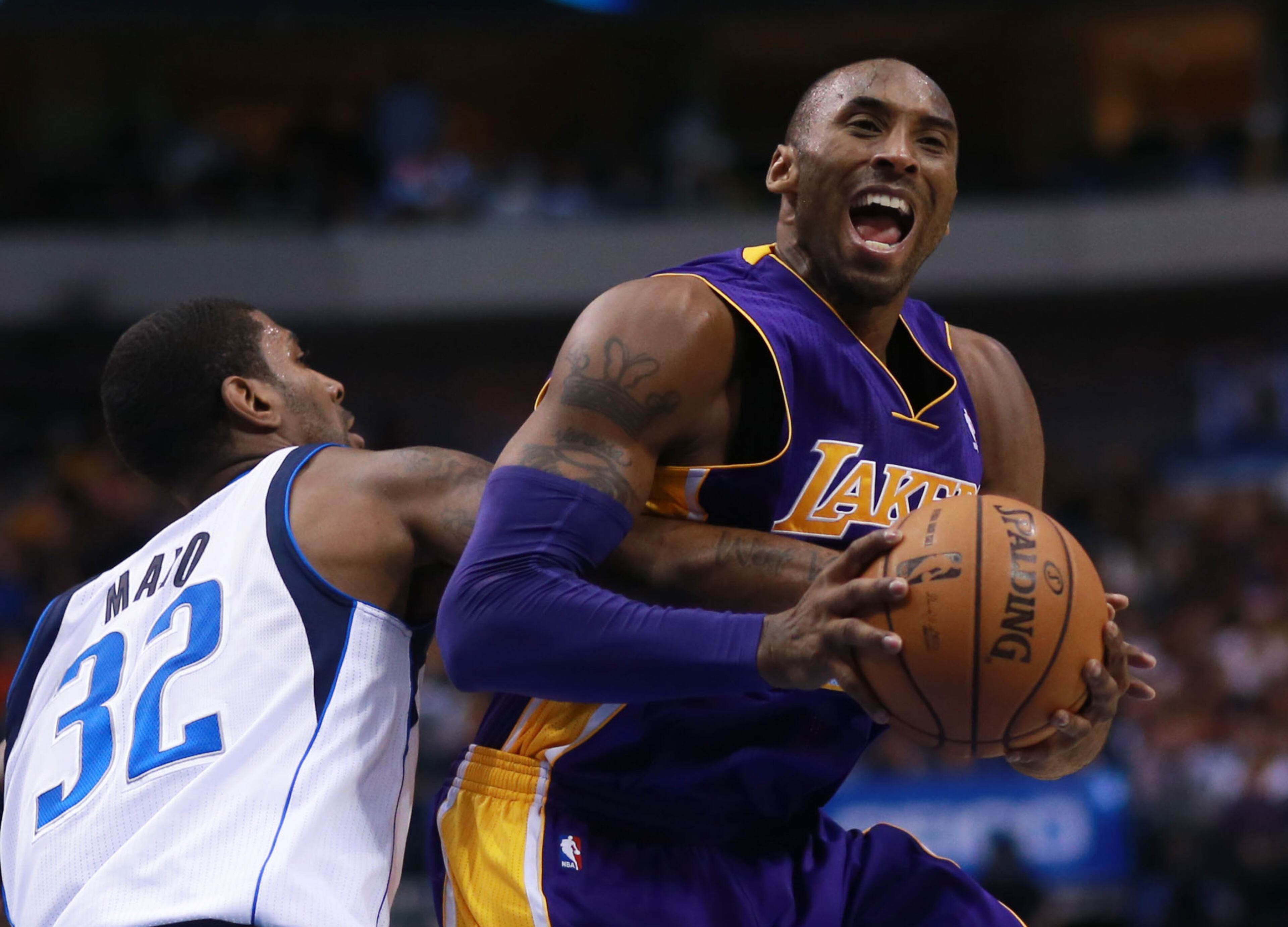 Los Angeles Lakers shooting guard Kobe Bryant, right, takes a foul from Dallas Mavericks shooting guard O.J. Mayo (32) in the first half of an NBA basketball game on Saturday, Nov. 24, 2012, in Dallas. (AP Photo/Michael Mulvey)