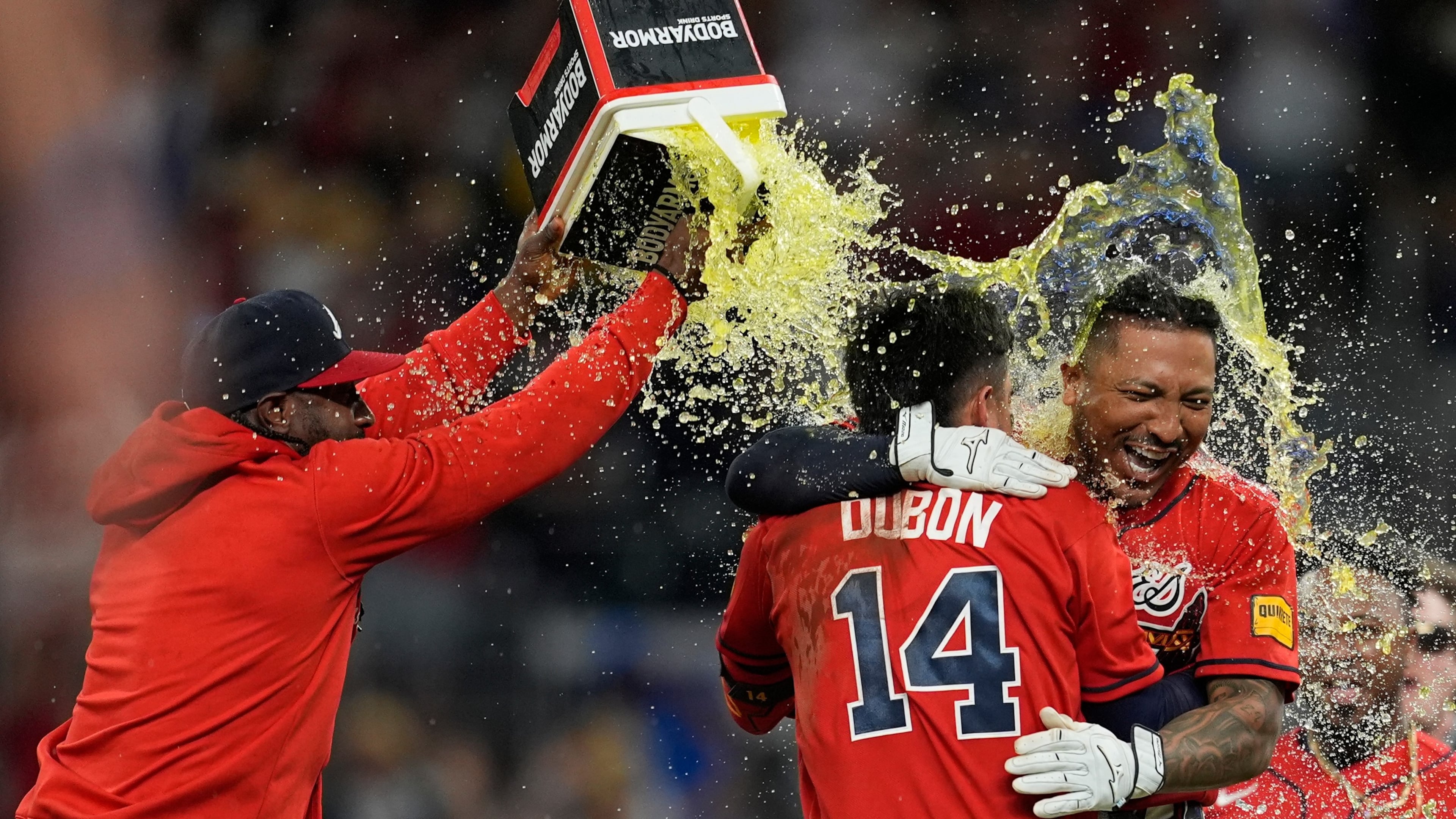 Atlanta Braves' Chadwick Tromp embraces Mauricio Dubón (14) after hitting the game-winning RBI-Single in the 11th inning of a baseball game against the Washington Nationals, Friday, May 22, 2026, in Atlanta. (AP Photo/Mike Stewart)