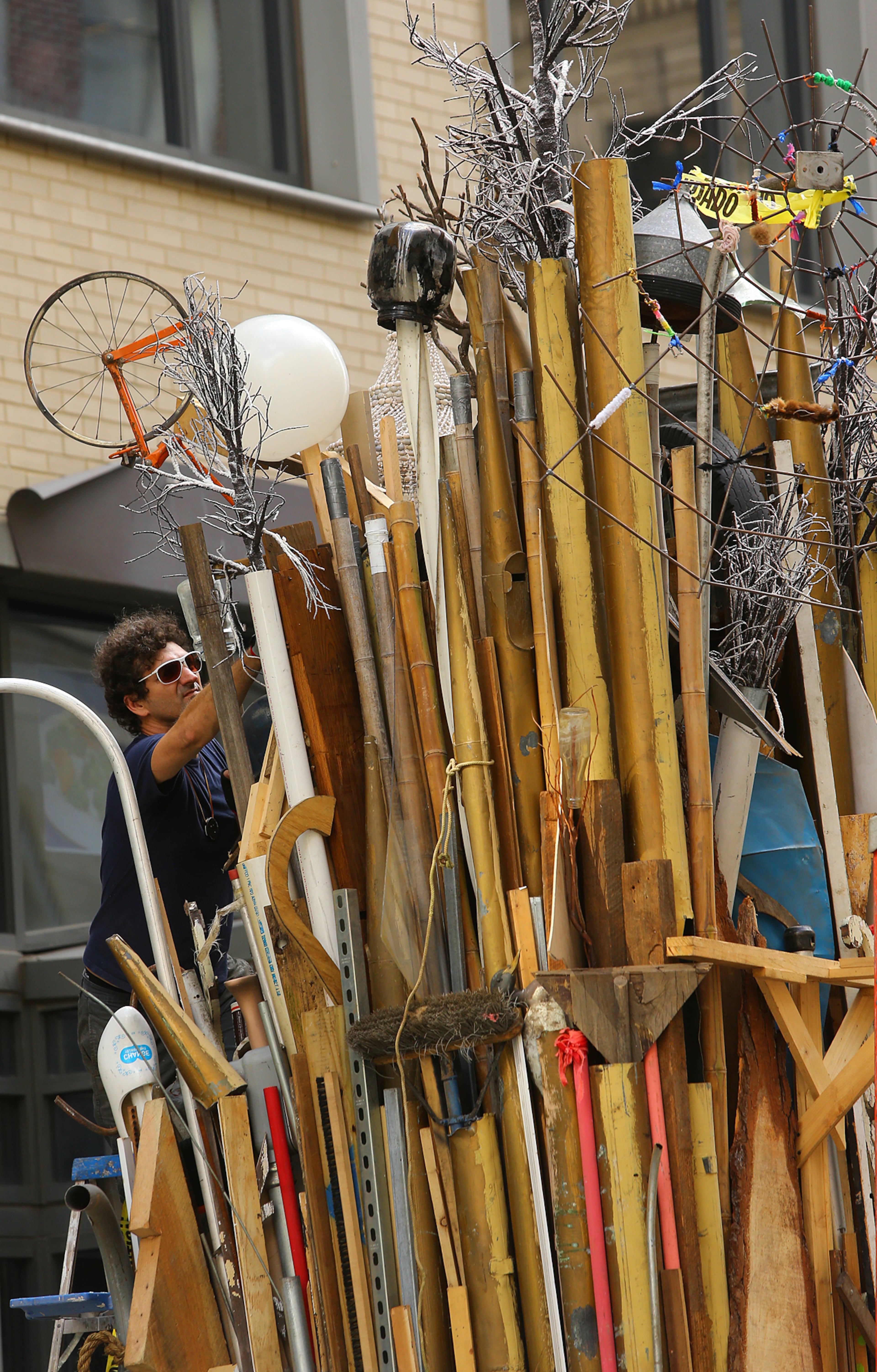 Savannah artist Marcus Kenney adds part of a mannequin to his work while transforming a Dumpster for his art installation "Timeline" Monday, Oct. 13, 2014 on Forsyth Street in Atlanta. 20 artists were given 10 big trash receptacles to create a work of public art that will be part of this year's Elevate, the Office of Cultural Affairs' free week-long public art event from Oct. 17-23. CURTIS COMPTON / CCOMPTON@AJC.COM