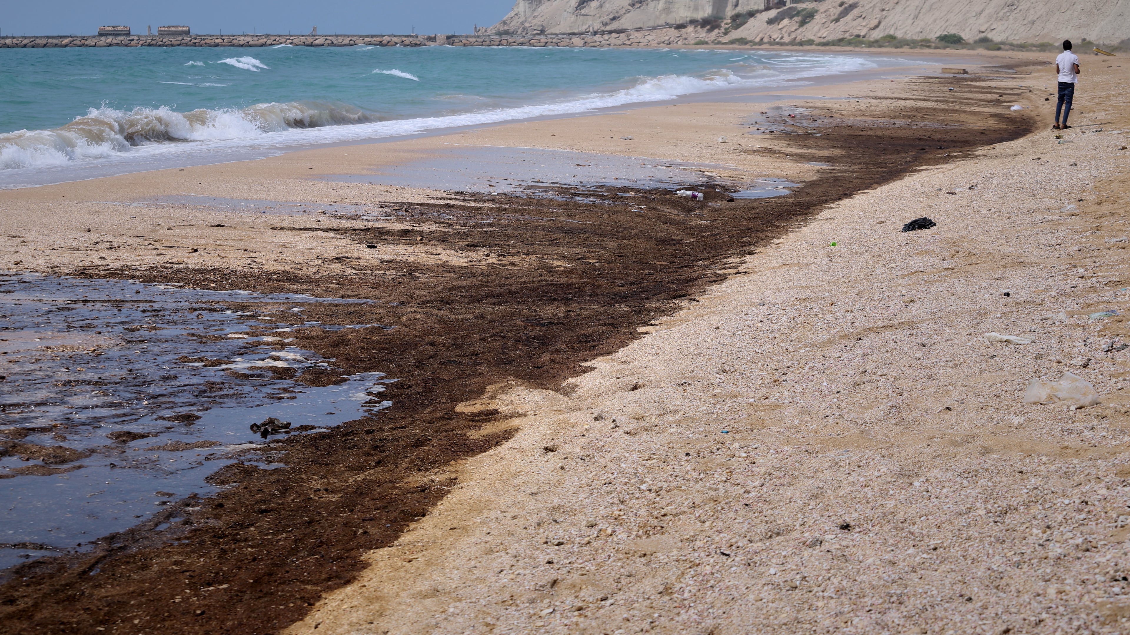 Dark oil residue covers parts of the shoreline at Shib Deraz Beach on Qeshm Island, Iran, Thursday, Aug. 13, 2026, amid ongoing wartime attacks on vessels and infrastructure in and around the Strait of Hormuz, though the spill’s source has not been independently determined. (Amirhosein Khorgooei/ISNA)
