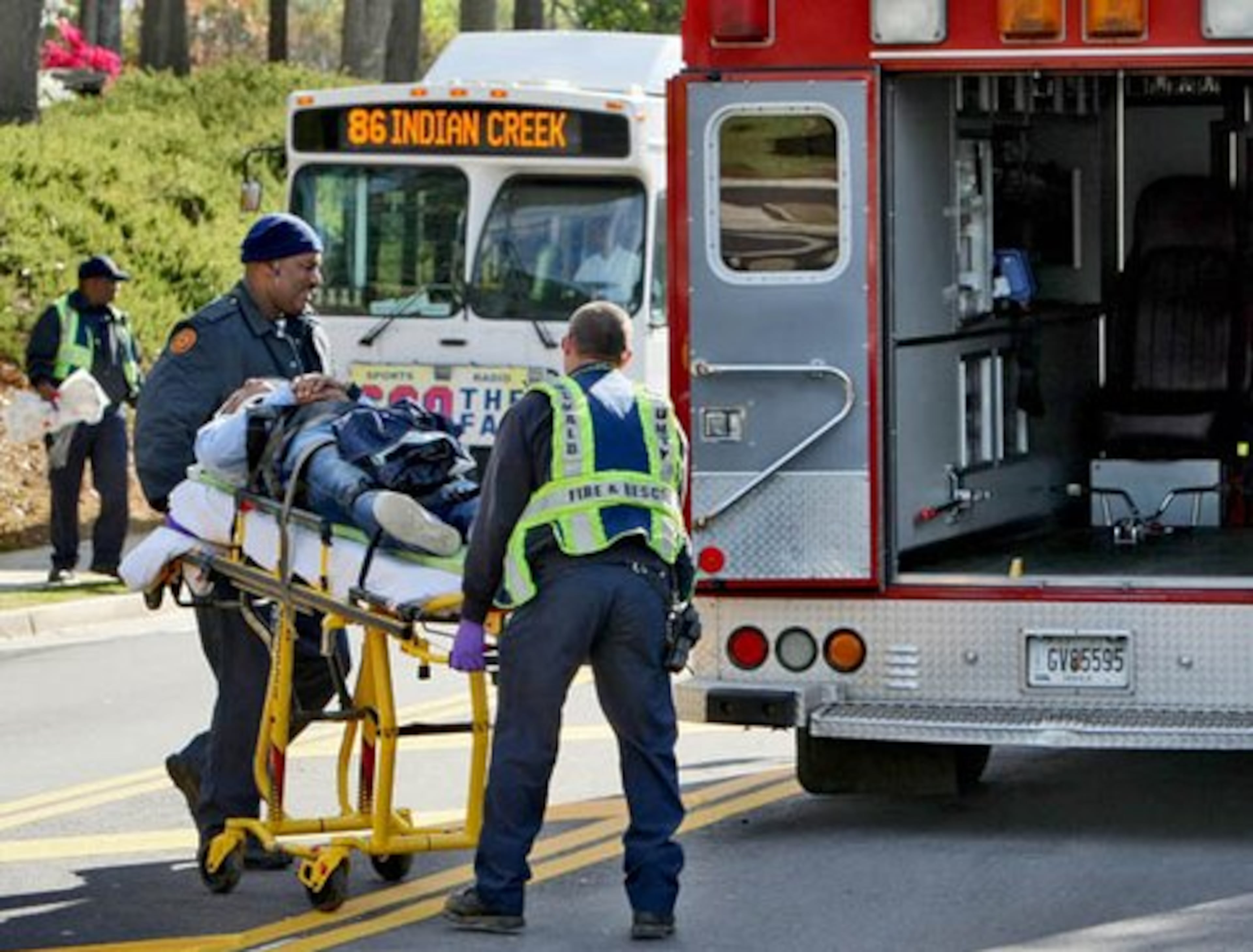 A patient is wheeled toward an emergency vehicle.