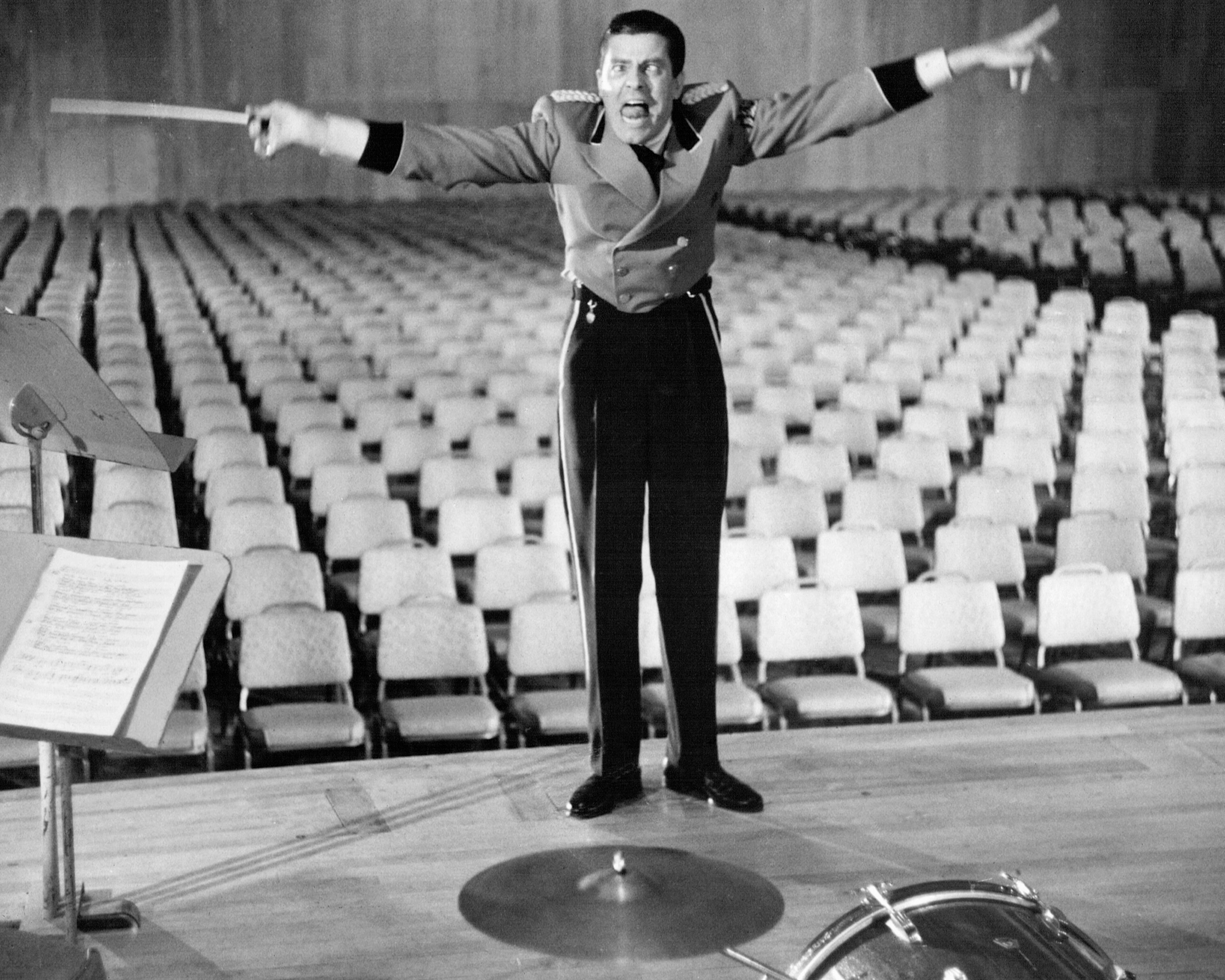 American actor and comedian Jerry Lewis as Stanley the bellboy, conducting an imaginary orchestra in an empty theatre, in 'The Bellboy', 1960. Lewis also wrote, produced and directed the film. (Photo by Silver Screen Collection/Getty Images)