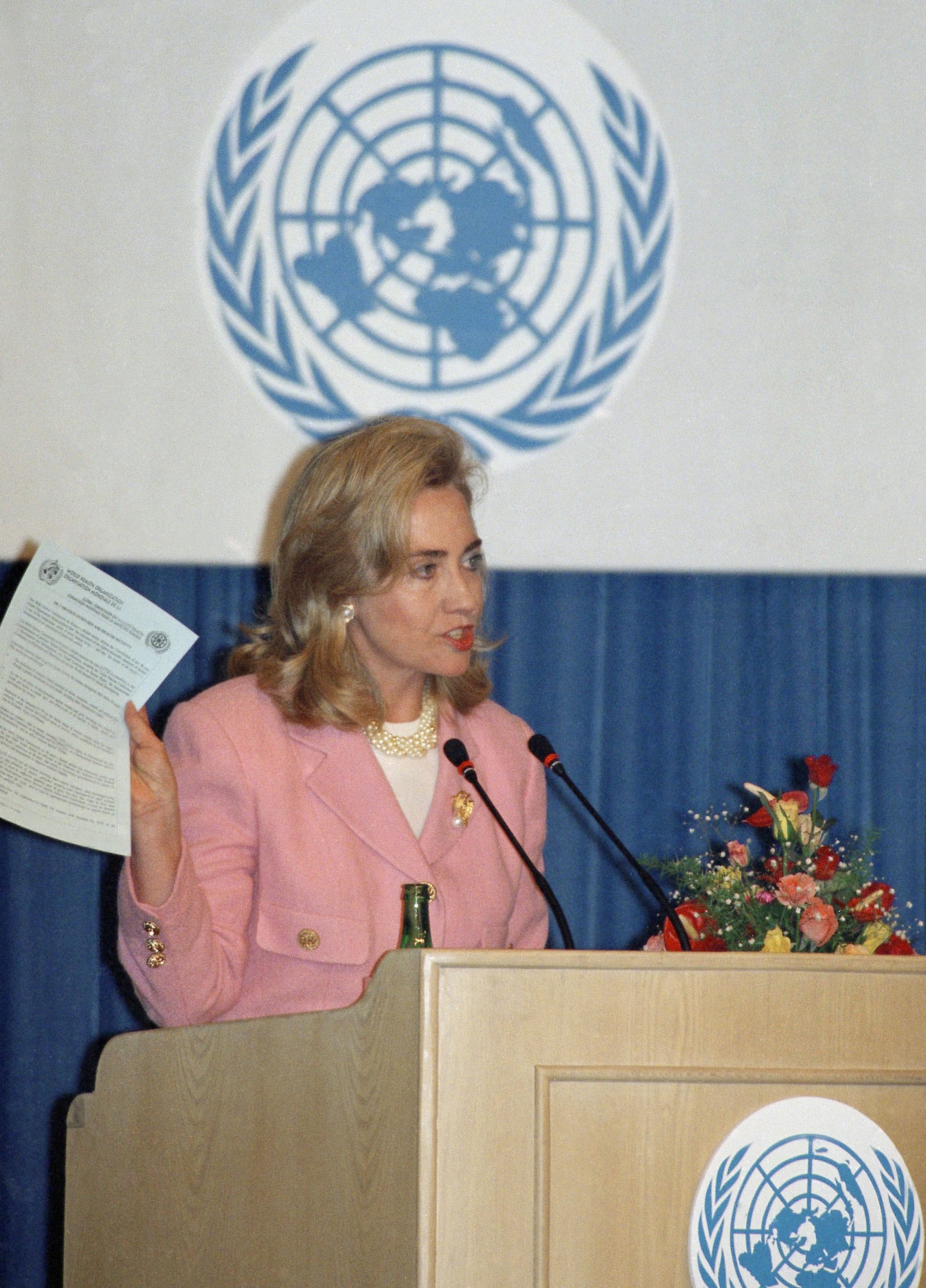 In this Tuesday, Sept. 5, 1995 file photo, first lady Hillary Clinton addresses a panel on women's health and security at the U.N. Women's Conference in Beijing. During the conference, she said, "Human rights are women's rights, and women's rights are human rights." Clinton holds a copy of a report entitled "Declaration on Women and Health Security." (AP Photo/Greg Baker)