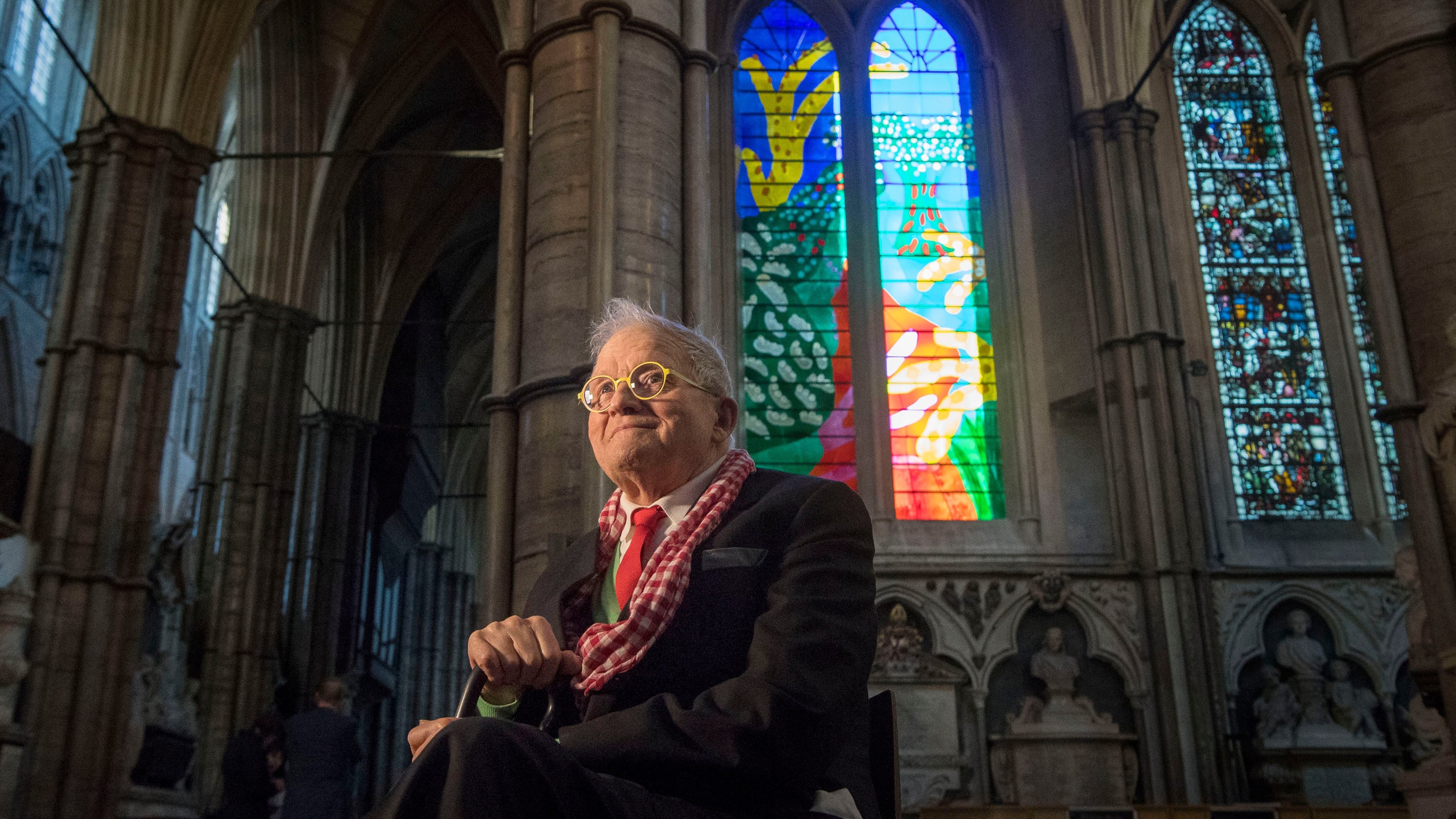 FILE - British artist David Hockney sits in front of The Queen's Window, a new stained glass window at Westminster Abbey, London, designed by David Hockney and revealed for the first time on Wednesday Sept. 26, 2018. (Victoria Jones/Pool via AP, File)