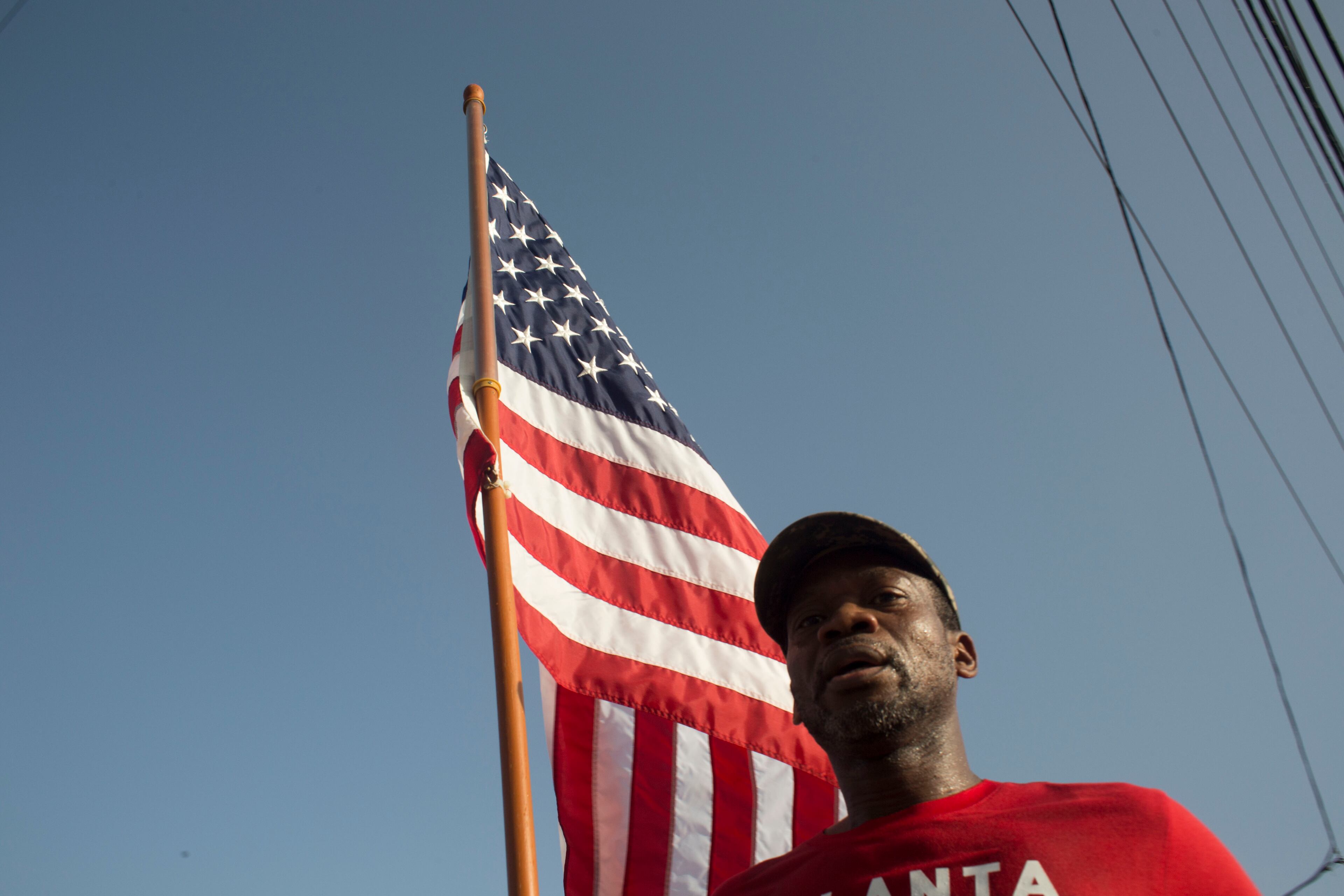 A participant in the Peachtree Road Race wields an American flag at approximately the four mile mark of the course. Chad Rhym/ Chad.Rhym@ajc.com