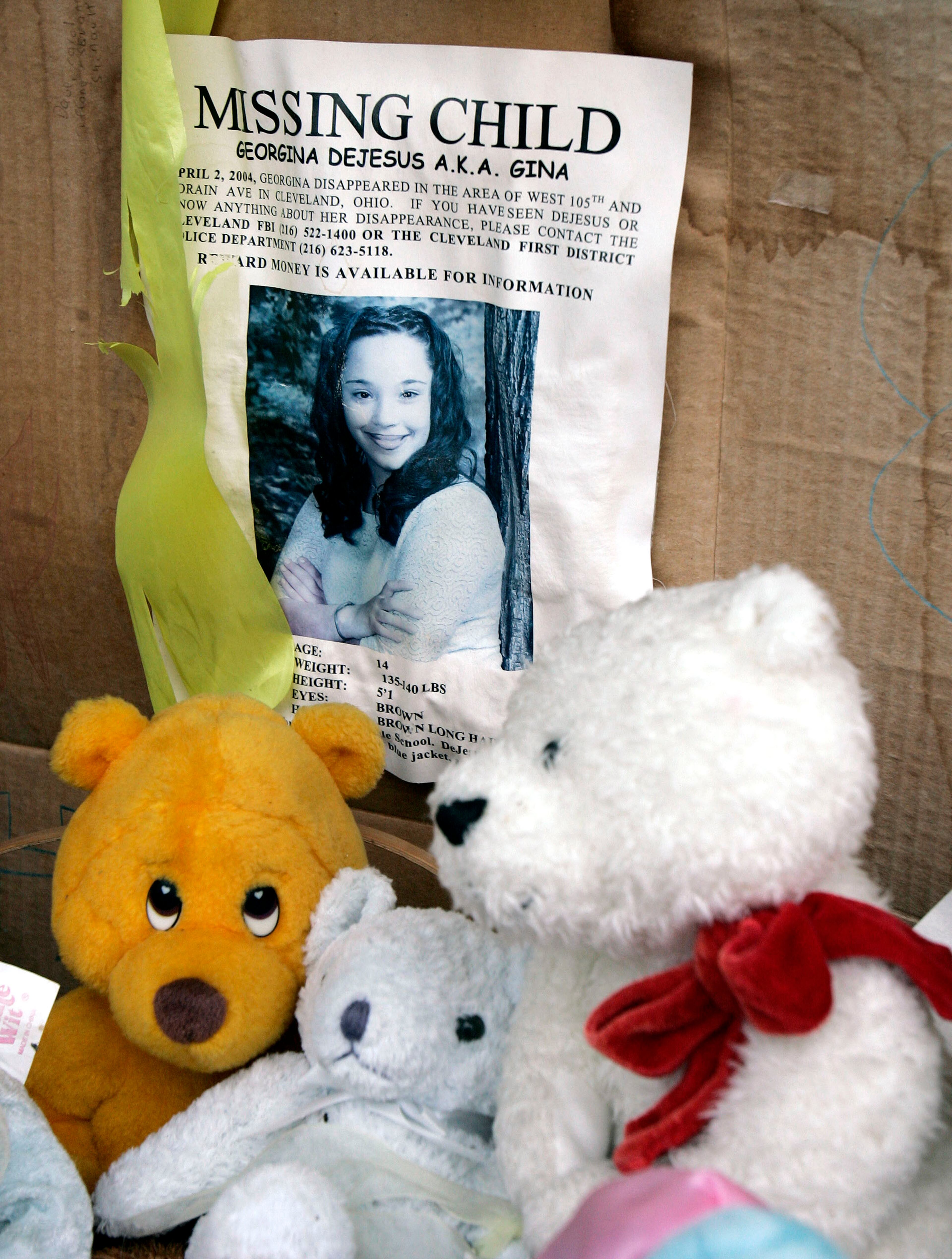 In this March 3, 2006 file photo, a memorial for Gina DeJesus, who has been missing since April 2, 2004, rests alongside her house in Cleveland. Cleveland police say DeJesus, one of two women who went missing as teenagers about a decade ago has been found alive in a residential area about two miles (three kilometers) south of downtown. (AP Photo/Tony Dejak, File)