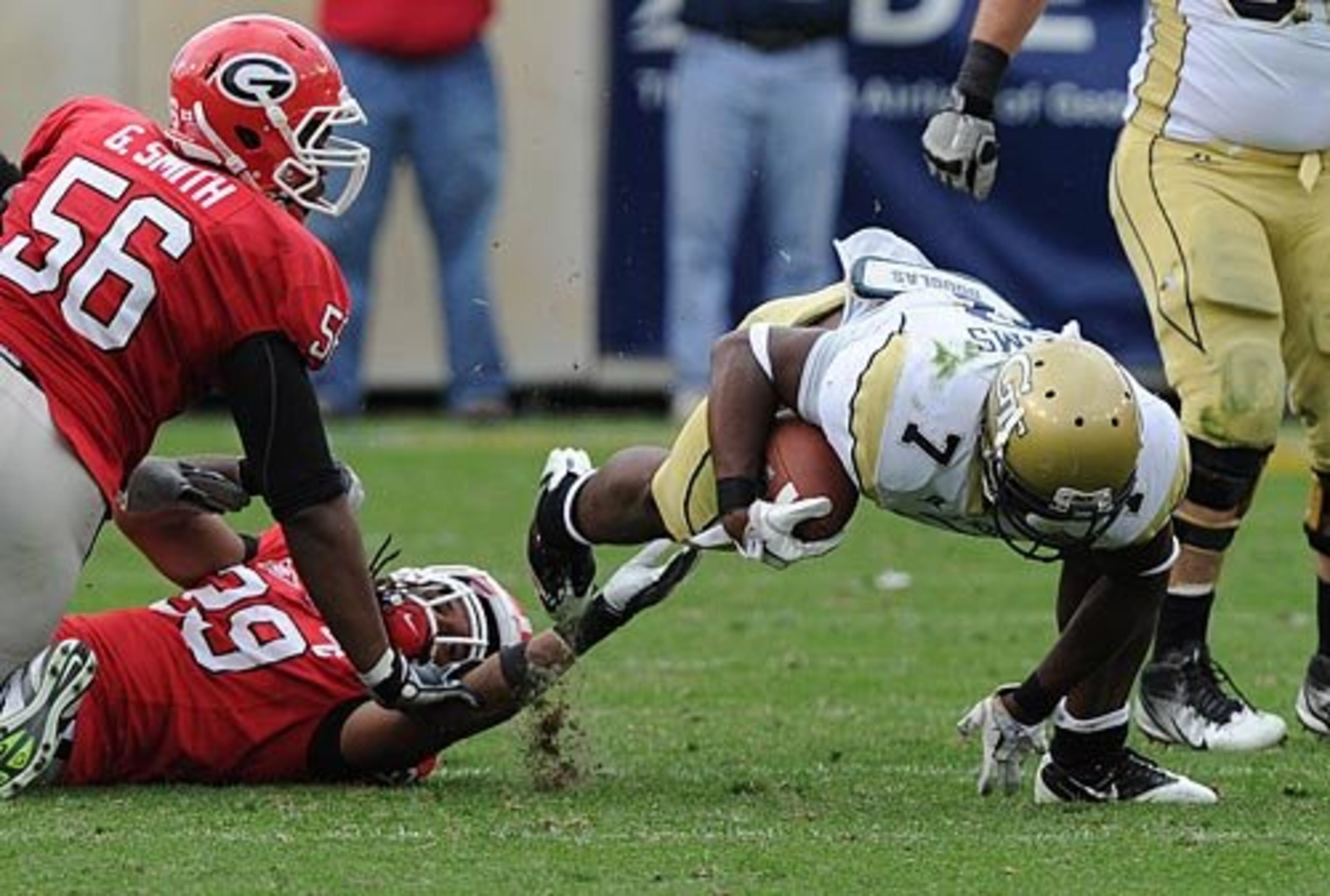 Georgia Tech's David Sims is tripped up by UGA defenders Jarvis Jones (29) and Garrison Smith (56) in the fourth quarter.