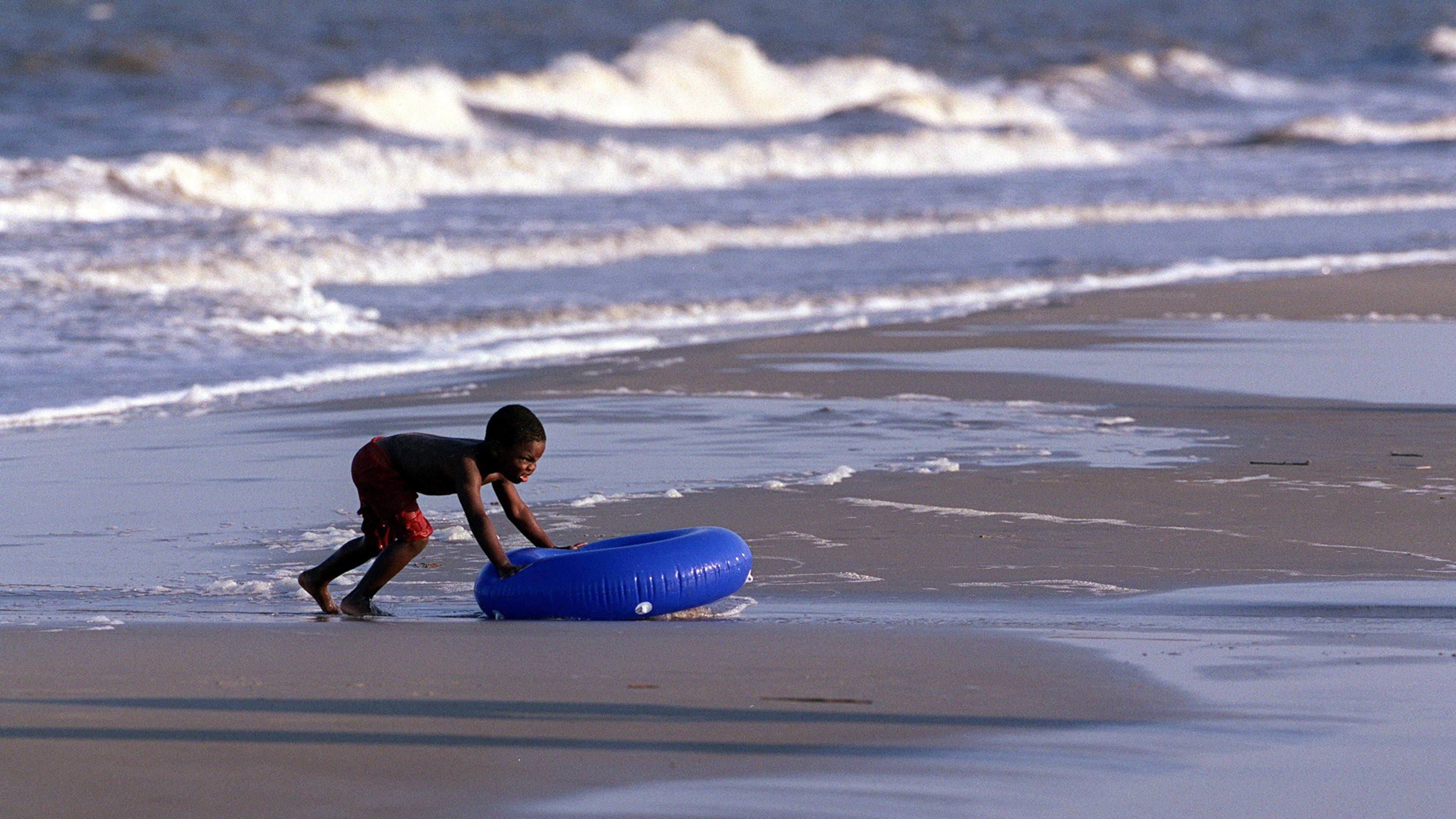 A boy plays in the surf in the Atlantic on Jekyll Island. (Louie Favorite/AJC 2001)