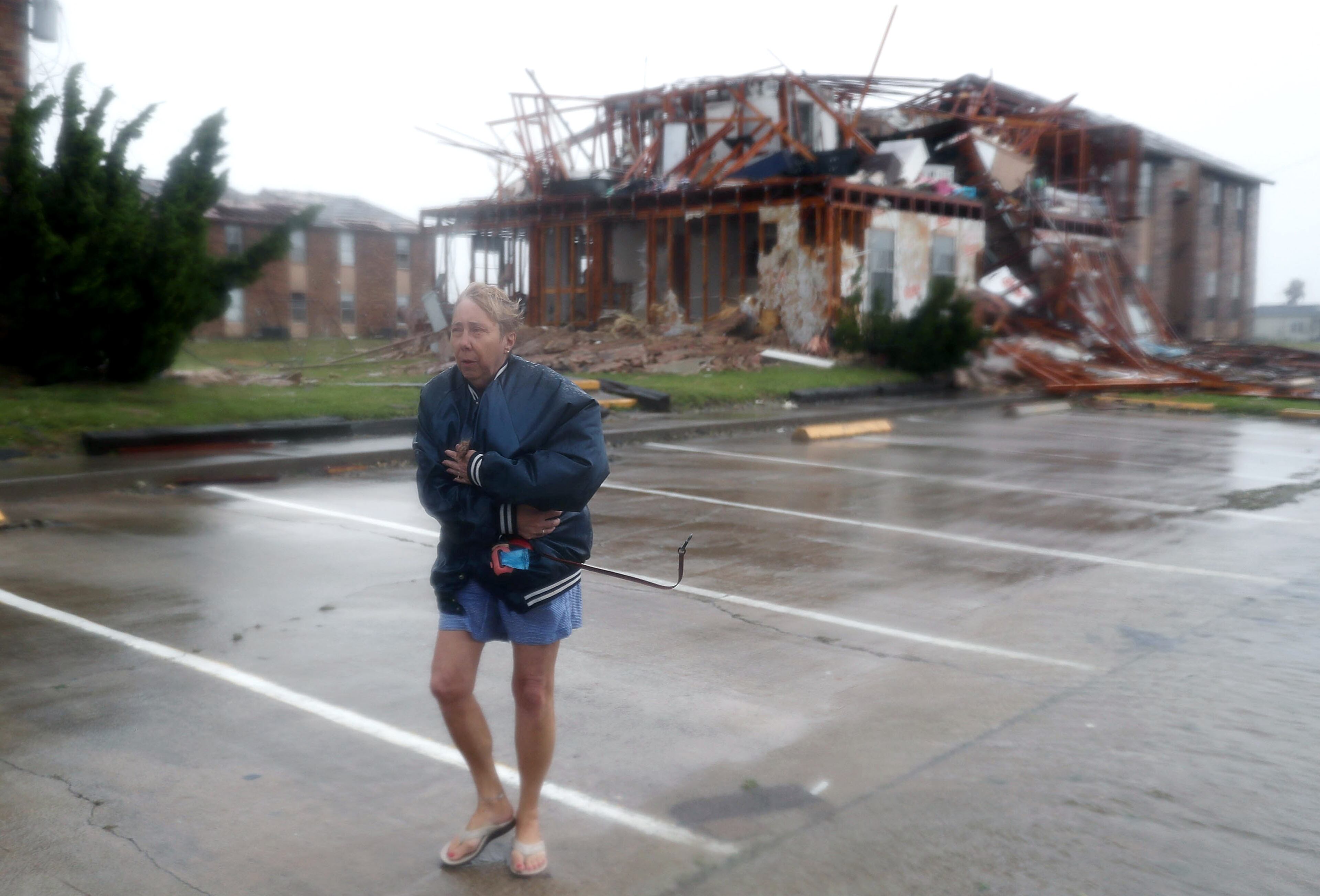ROCKPORT, TX - AUGUST 26: Jacque McKay walks through the apartment complex where she lives and road out the storm after Hurricane Harvey destroyed many of the apartments on August 26, 2017 in Rockport, Texas. Ms. McKay said she was able to rescue her dog but lost pretty much everything else. Harvey made landfall shortly after 11 p.m. Friday, just north of Port Aransas as a Category 4 storm and is being reported as the strongest hurricane to hit the United States since Wilma in 2005. Forecasts call for as much as 30 inches of rain to fall in the next few days. (Photo by Joe Raedle/Getty Images)