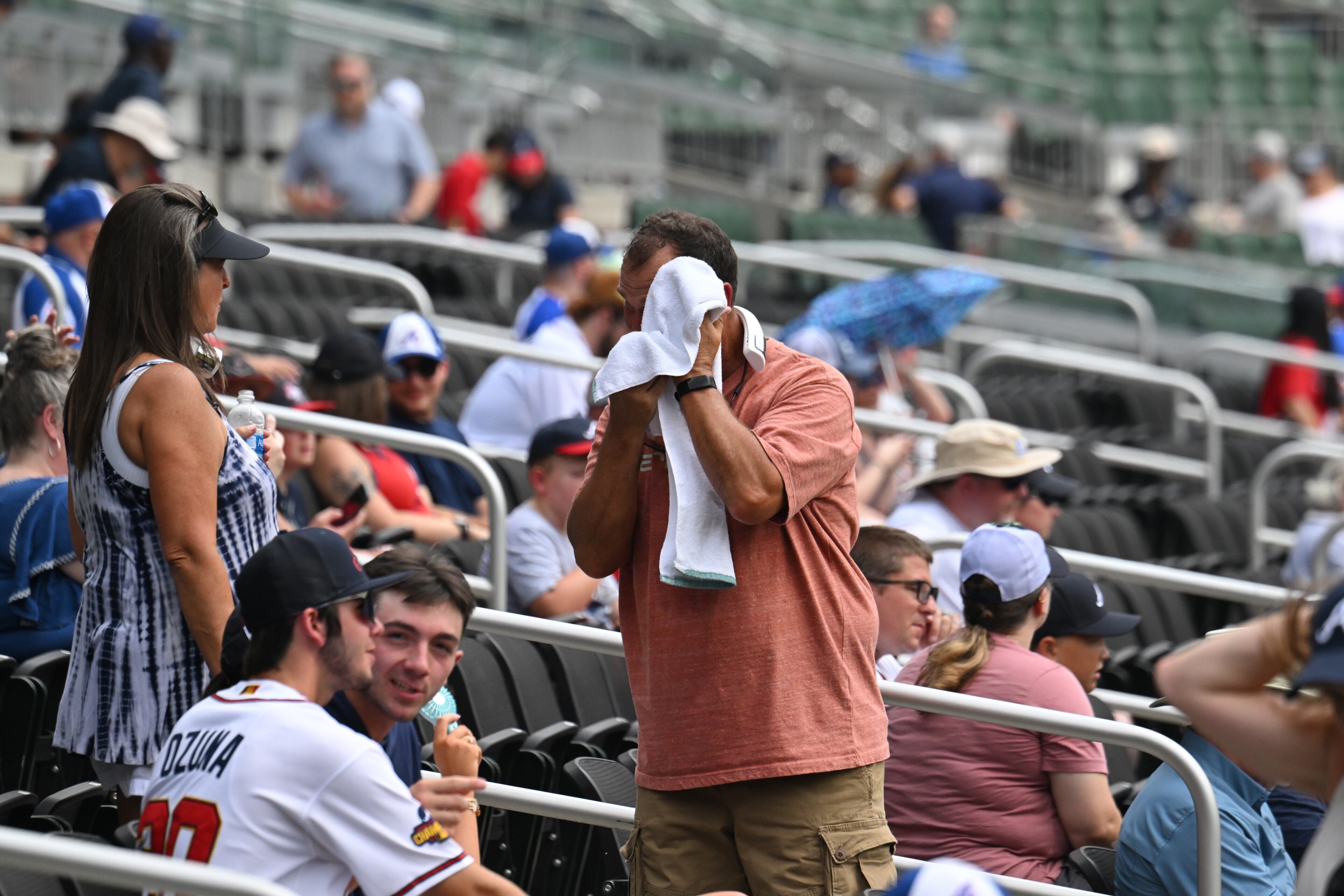 A baseball fan wipes his sweat as he waits for Atlanta Braves home game against the Arizona Diamondbacks at Truist Park, Thursday, July 20, 2023, in Atlanta. The Braves won 7-5. (Hyosub Shin / Hyosub.Shin@ajc.com)