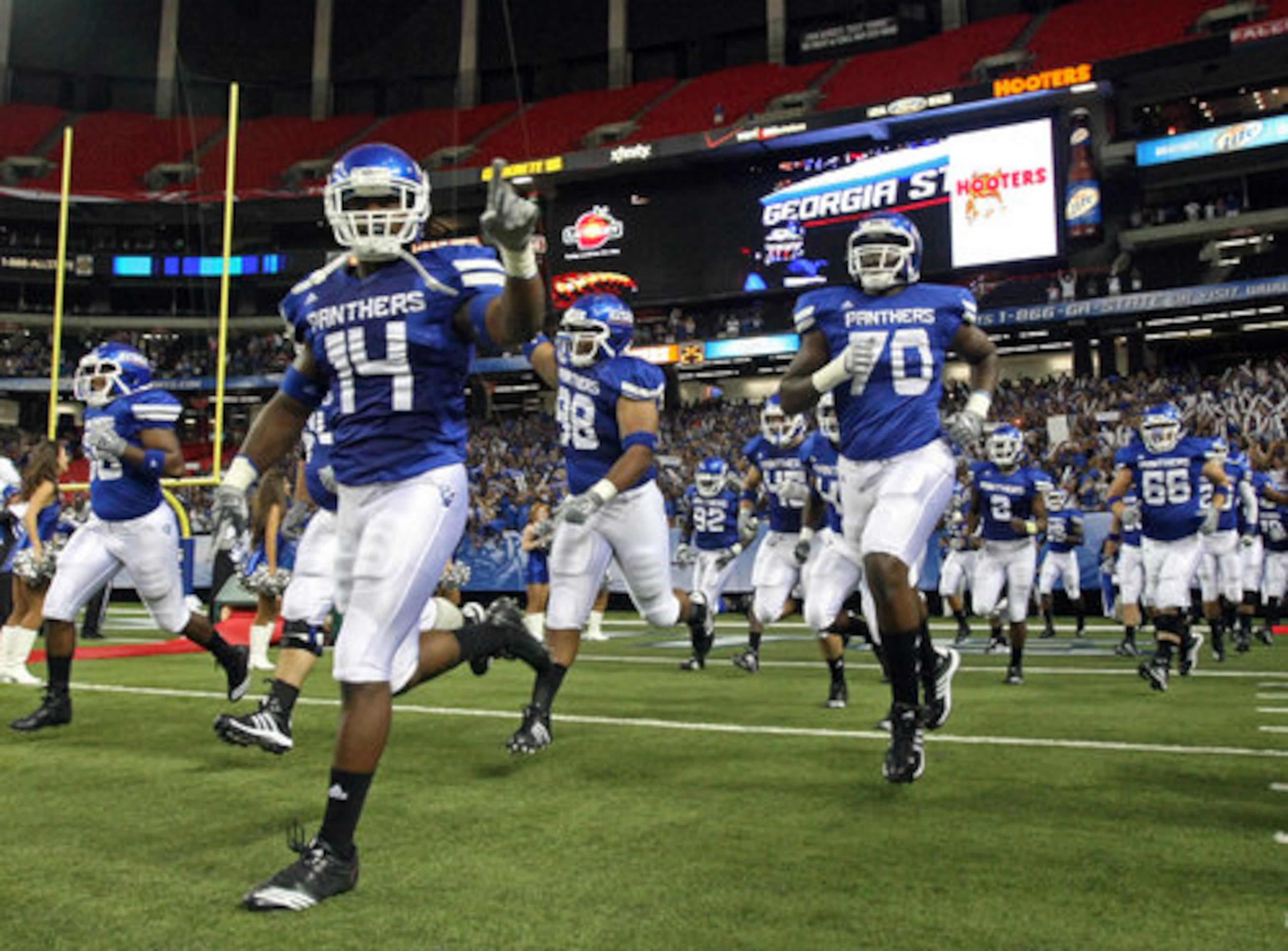 GSU players Jocquez Fears (14), Deron Jordan (98) and Ramell Davis (70) run onto the field for the first time before their inaugural game against Shorter College in the Georgia Dome Thursday night in Atlanta, Ga., Sept. 2, 2010.