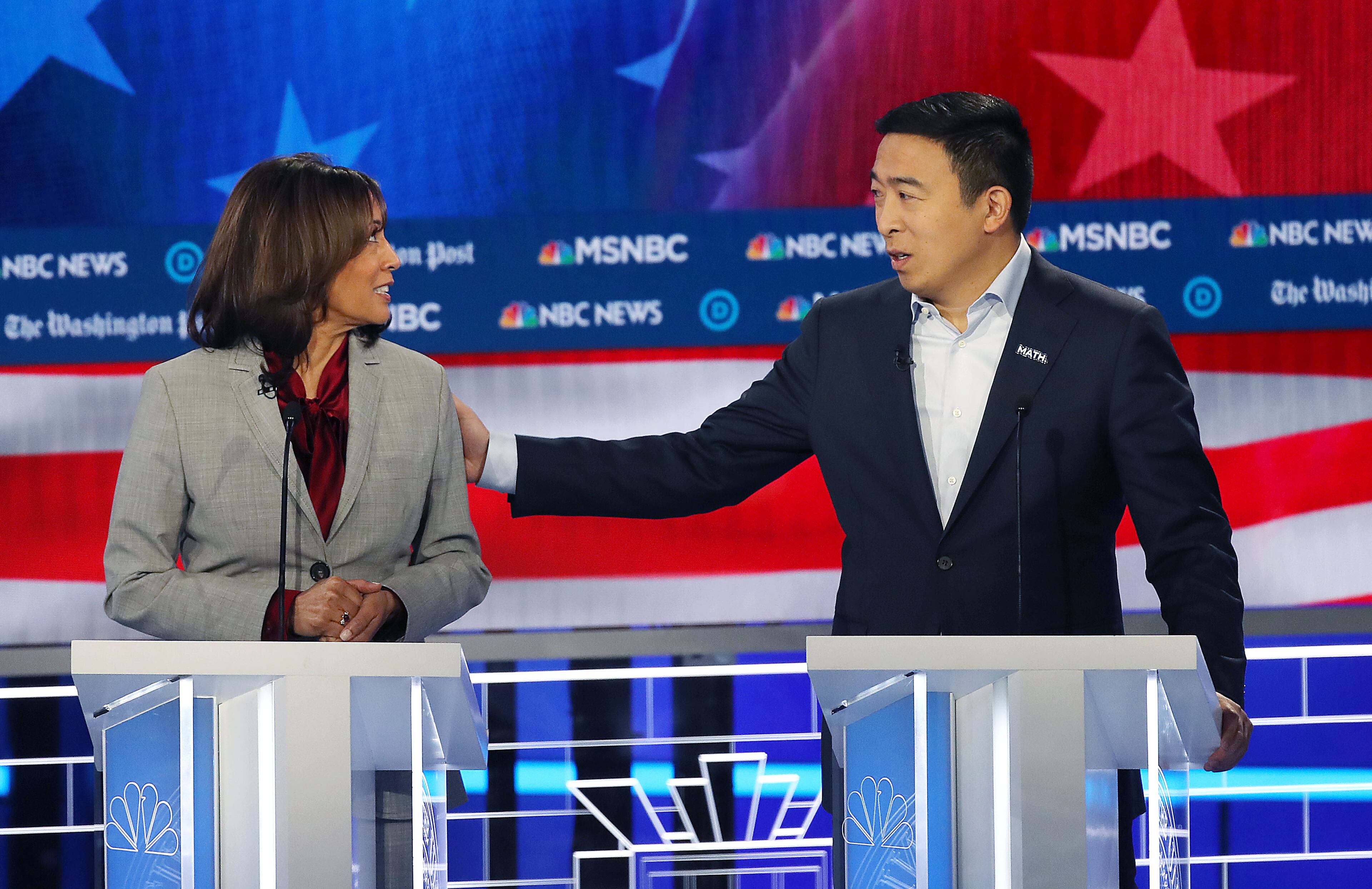 11/20/2019 -- Atlanta, Georgia -- Senator Kamala Harris (left) and Andrew Yang share a moment on stage, during the MSNBC/The Washington Post Democratic Presidential debate inside the Oprah Winfrey Soundstage at Tyler Perry Studios, Monday, November 20, 2019. (Alyssa Pointer/Atlanta Journal Constitution)